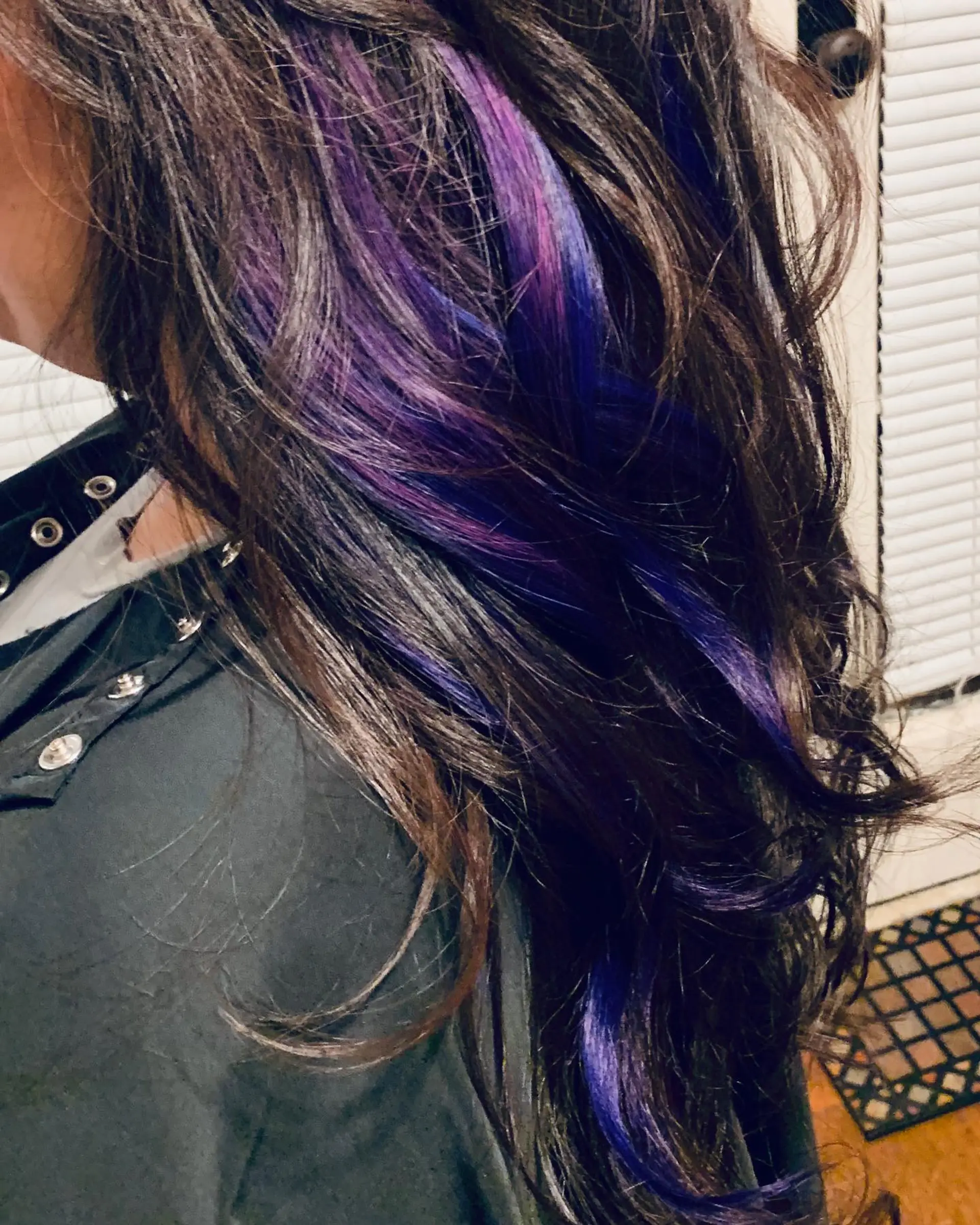 Long, layered dark wavy hair accented with vibrant purple and violet peekaboo extension streaks. 1