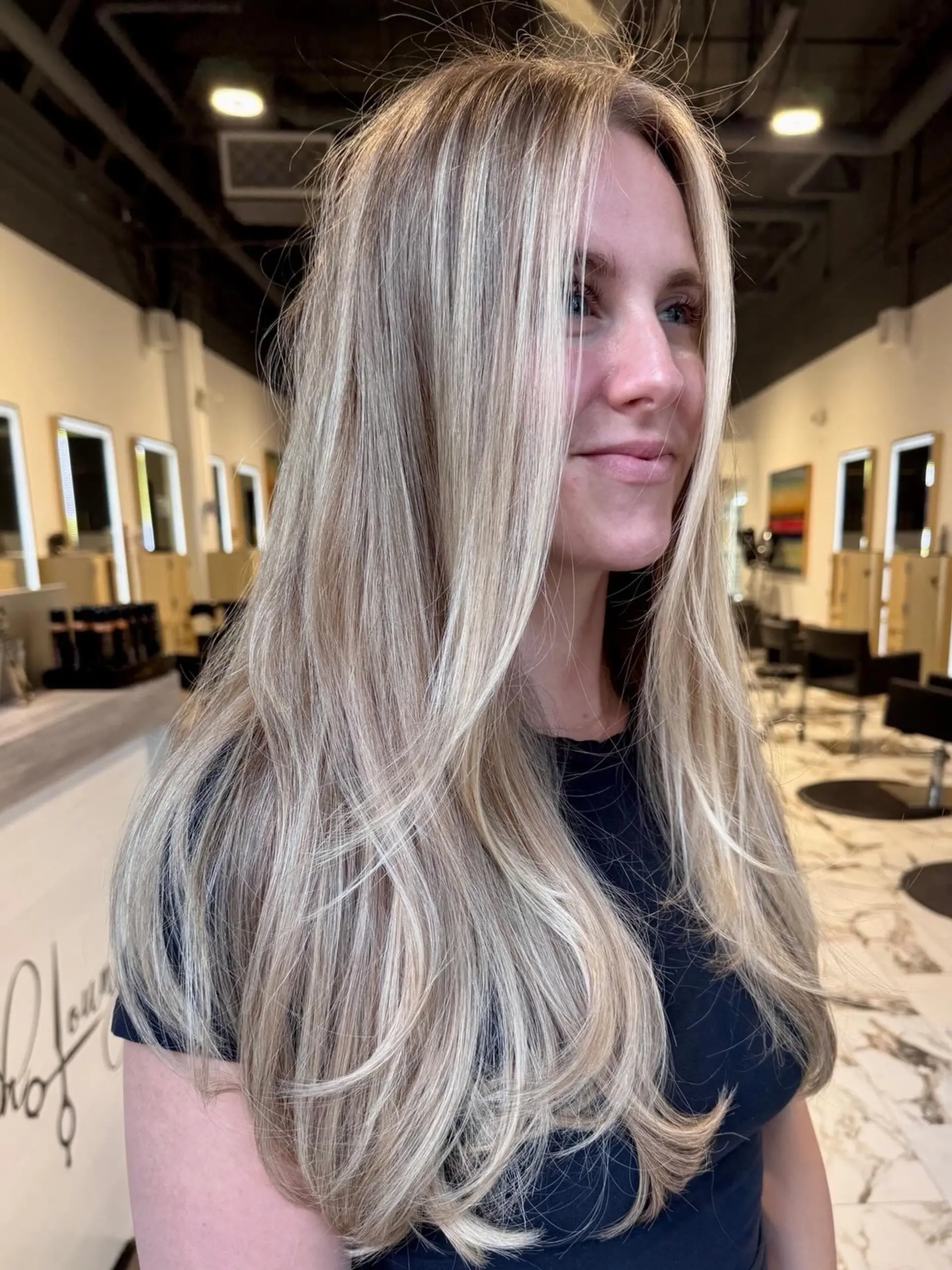 Long, flowing layers with finely blended full blonde highlights and a smooth, face-framing blowout. 1