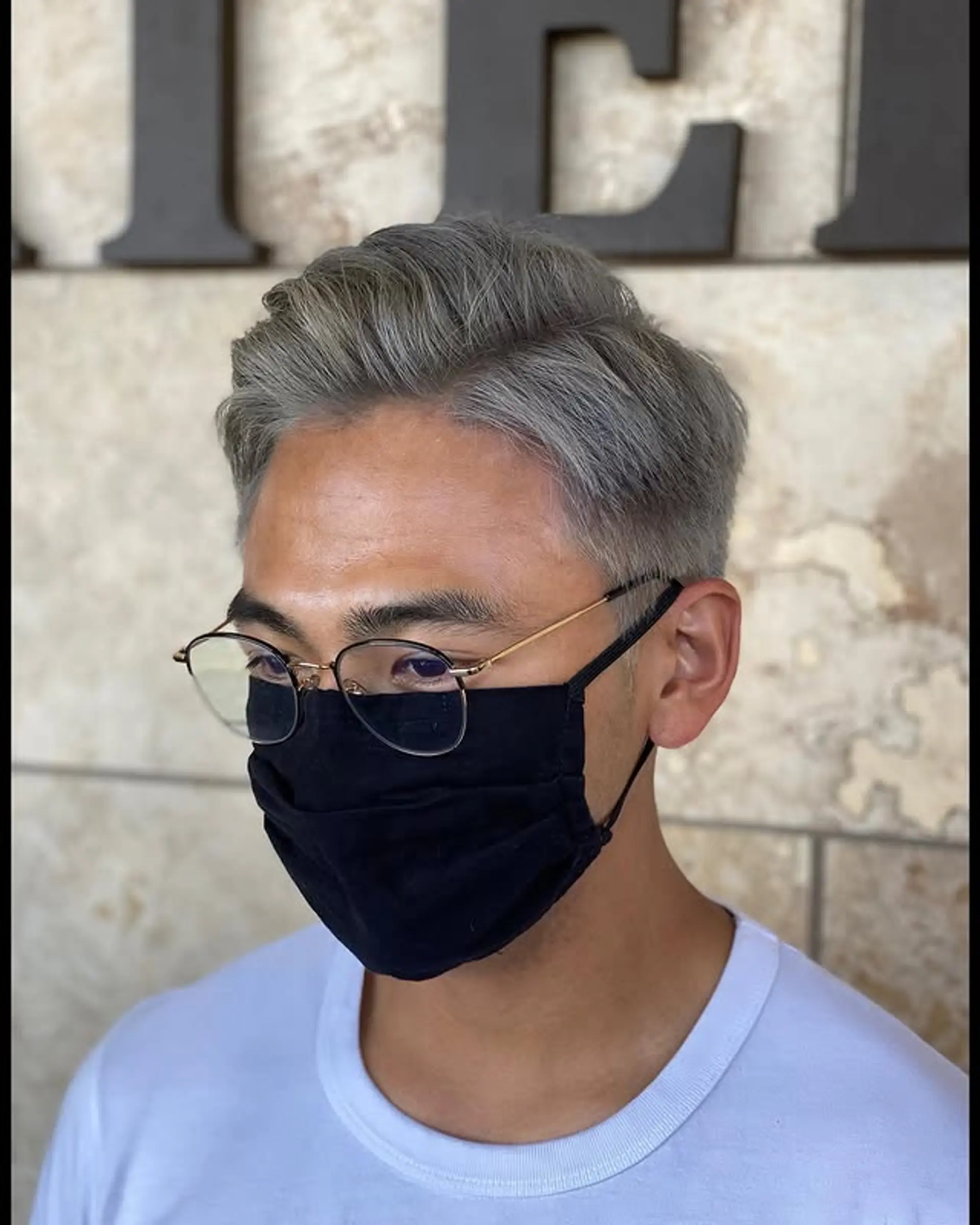 A short taper fade with a textured top, styled with a modern touch. 1