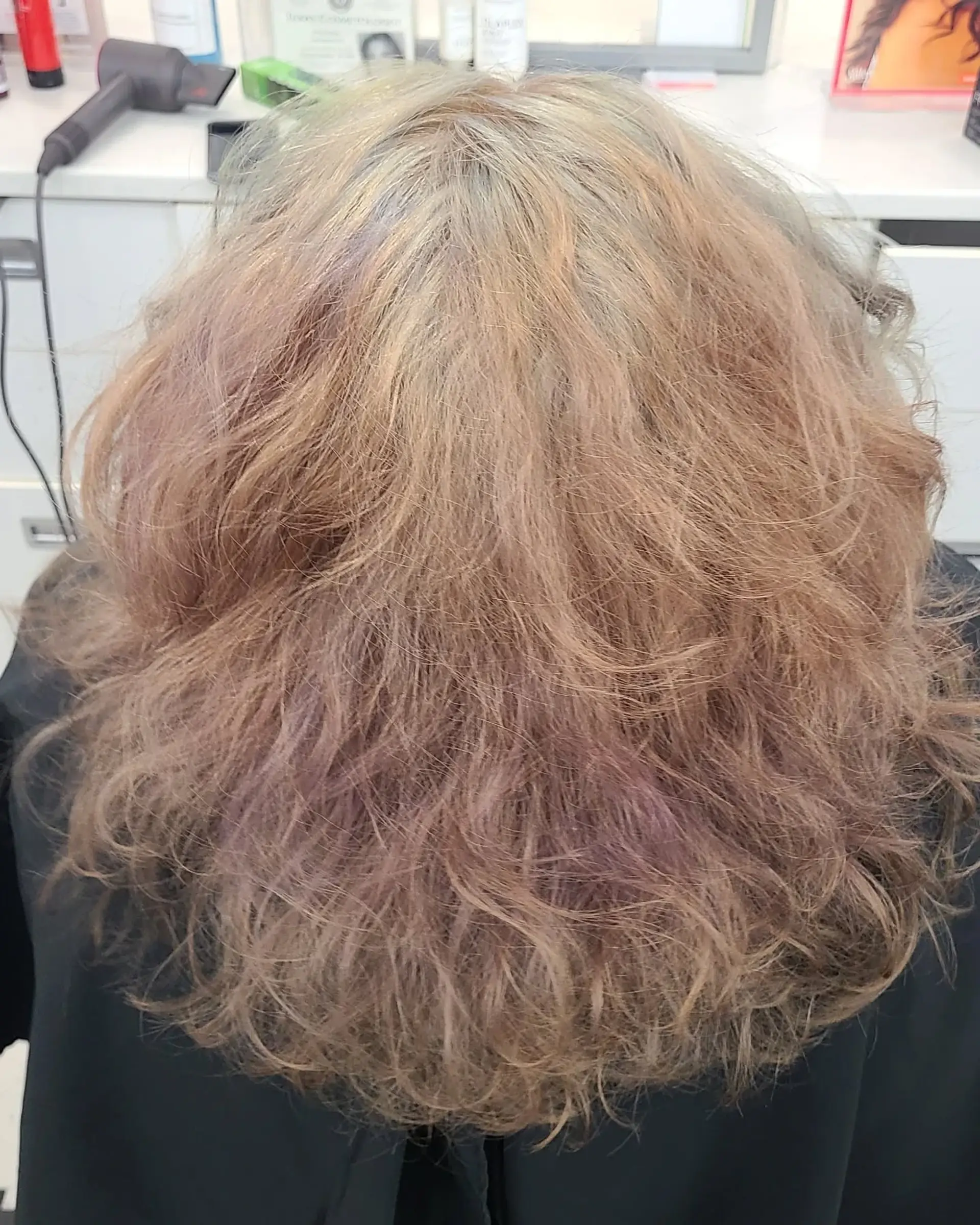 Long, wavy hair dyed in a striking rainbow palette of blues, pinks, purples, oranges, yellows, and greens, styled in a half-up twist secured with a decorative clip. 6
