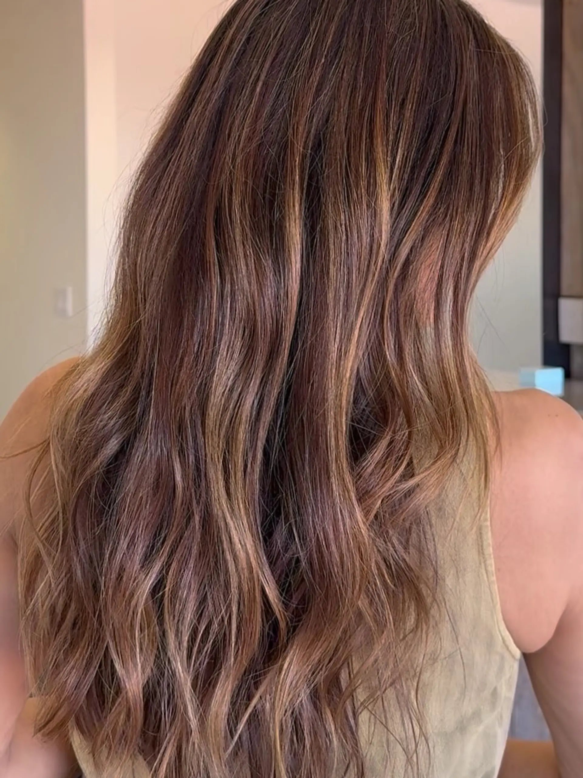 Long wavy brunette hair enhanced with soft caramel and warm brown balayage ribbons. 1