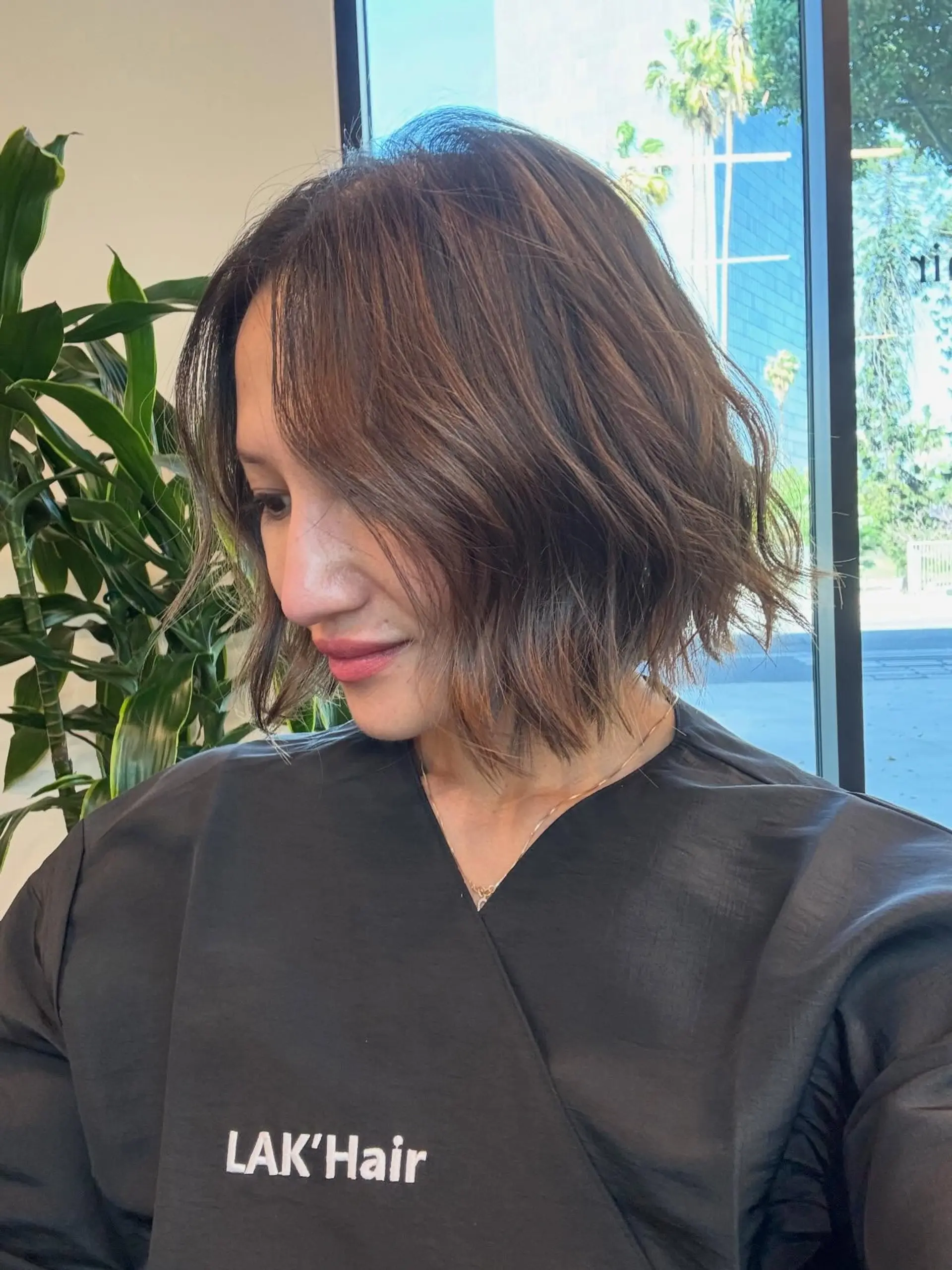 A textured chin-length bob styled with loose, undone waves and subtle multidimensional brown tones. 1