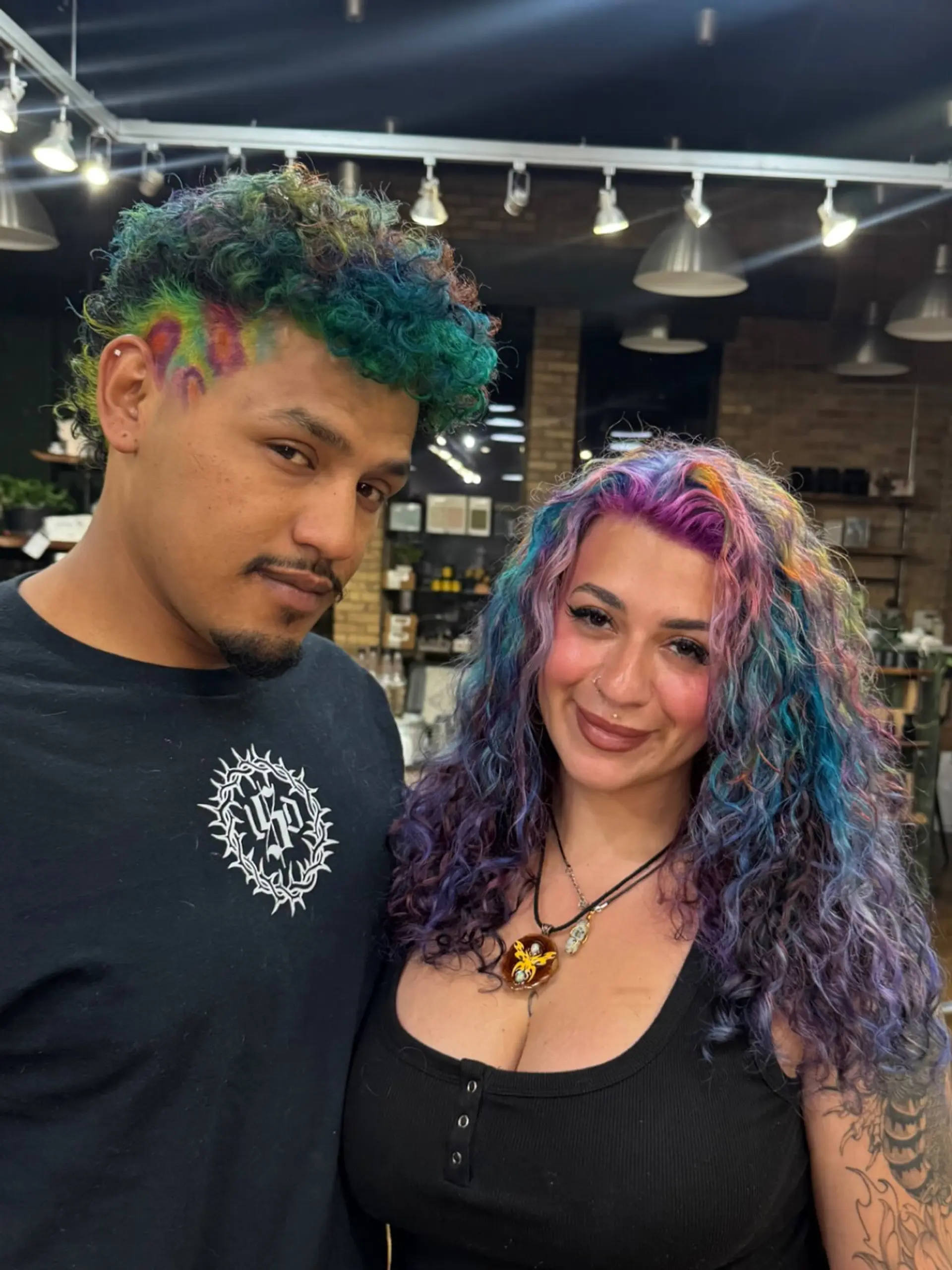 Vibrant custom multicolor vivid hair on defined curls paired with a graphic printed buzz fade. 1