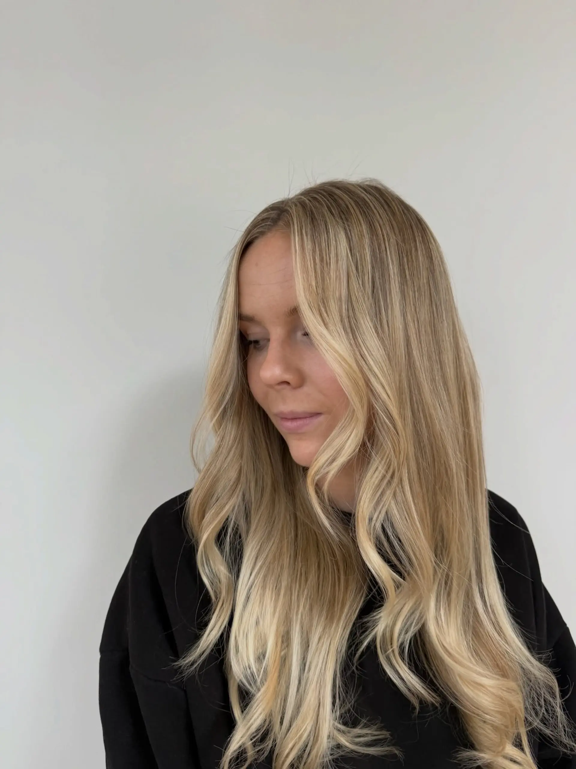 Long dimensional blonde hair styled with soft, loose waves and bright face-framing pieces. 1