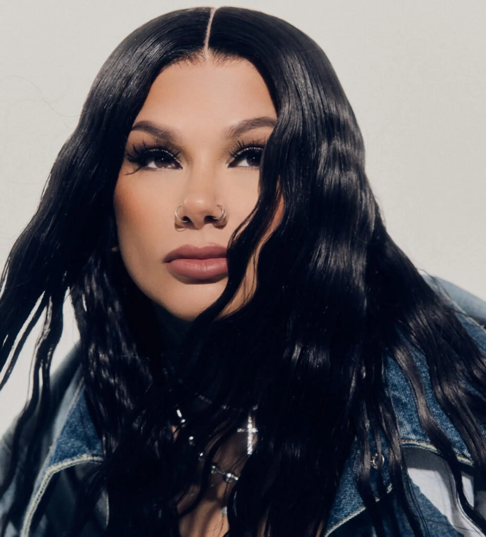 Long jet black hair styled with a defined center part and soft, glossy textured waves. 1