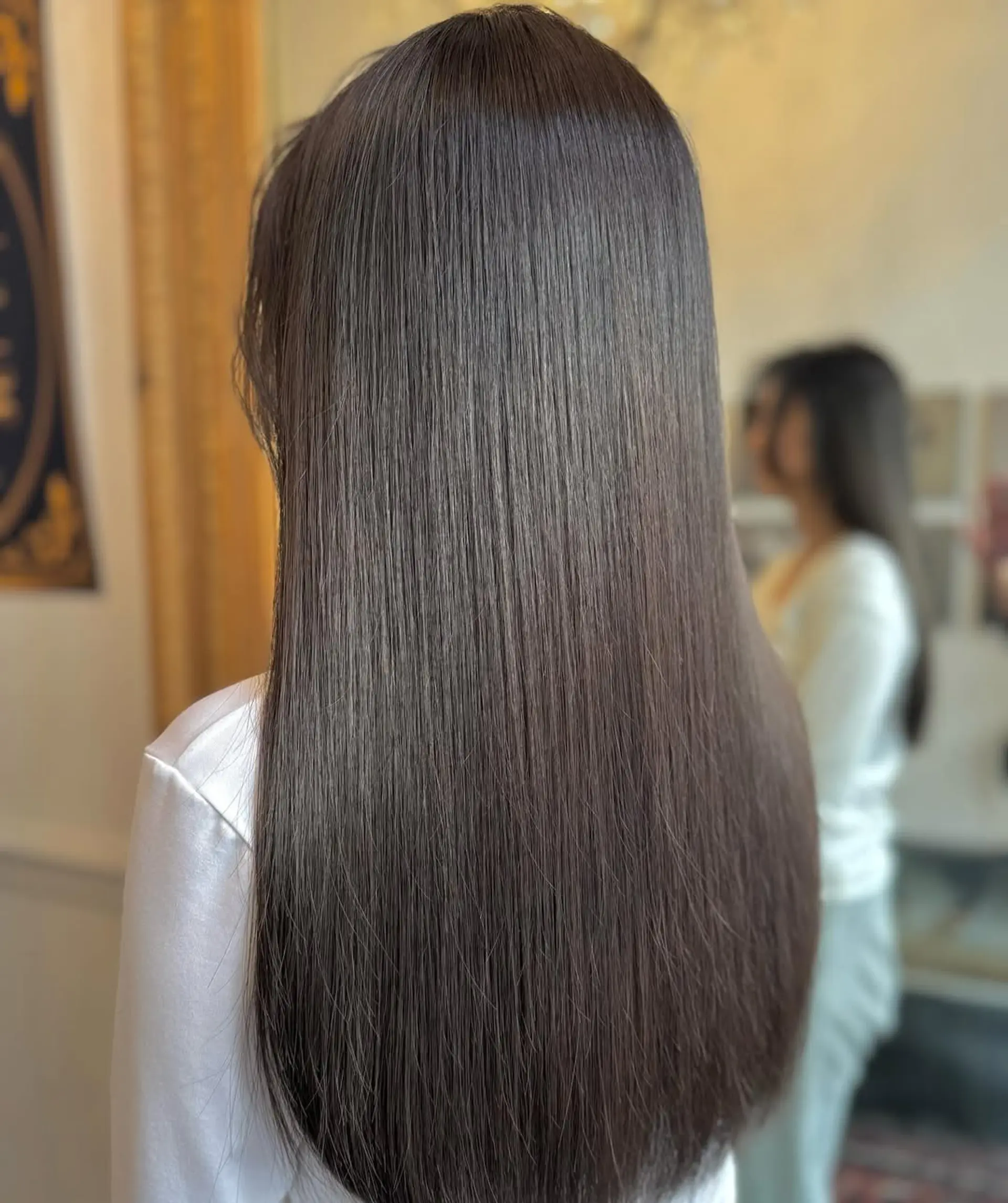 This style showcases very long, straight, and dark brown hair with sleek, glossy, and perfectly even strands. 2
