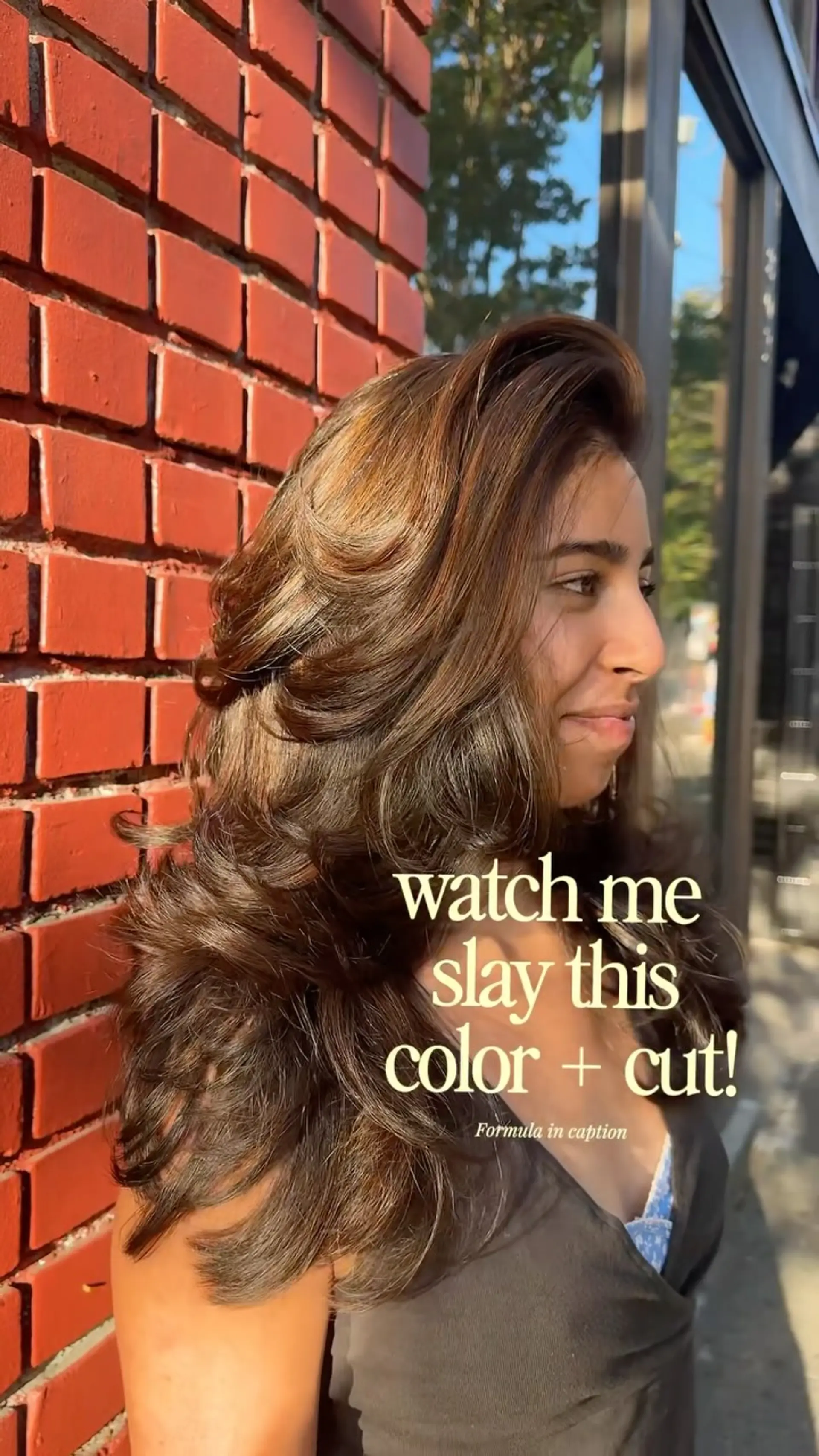 Long warm brunette hair cut with dramatic cascading layers and styled into a voluminous, feathered blowout. 1