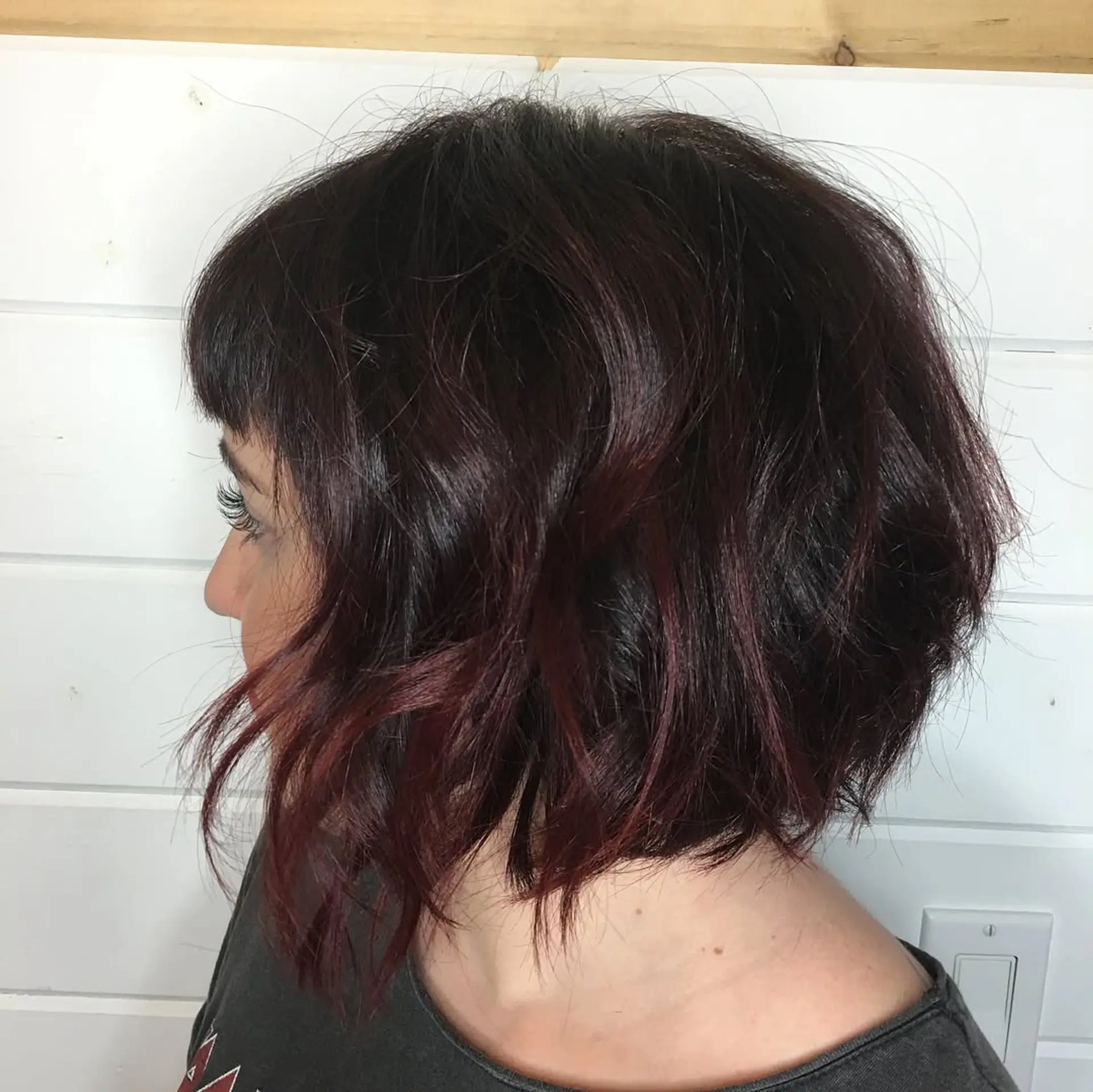 A textured chin-length bob styled in effortless tousled waves paired with straight blunt micro bangs. 1