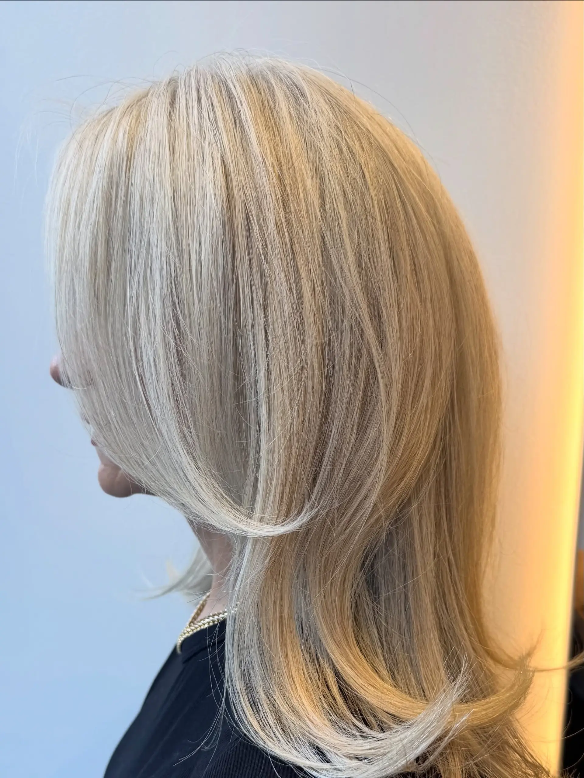 Medium-length blonde hair featuring finely blended highlights and soft, face-framing layers with flipped ends. 1
