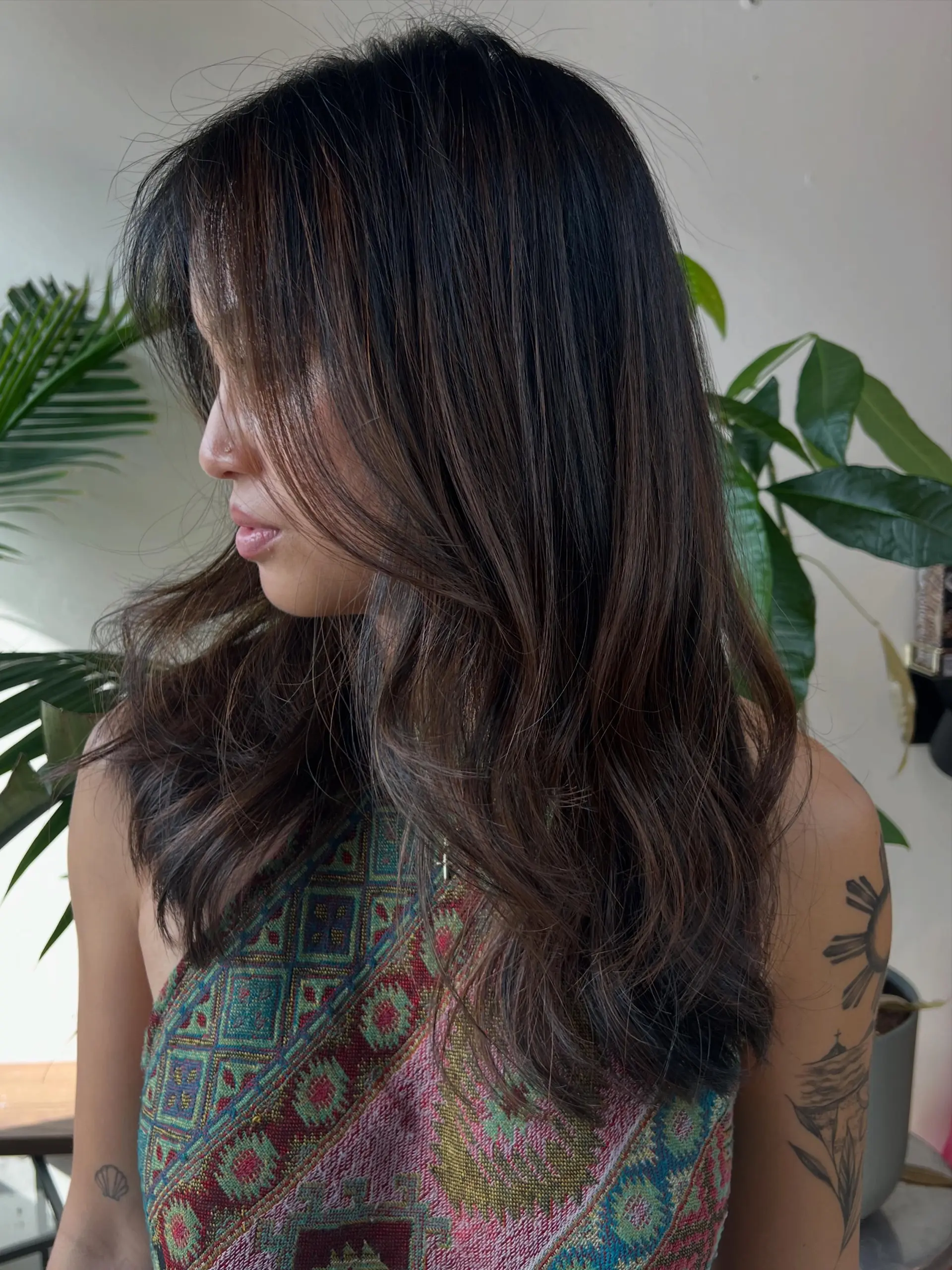 Dark brunette hair featuring a subtle partial balayage with soft face-framing fringe and loose waves. 1