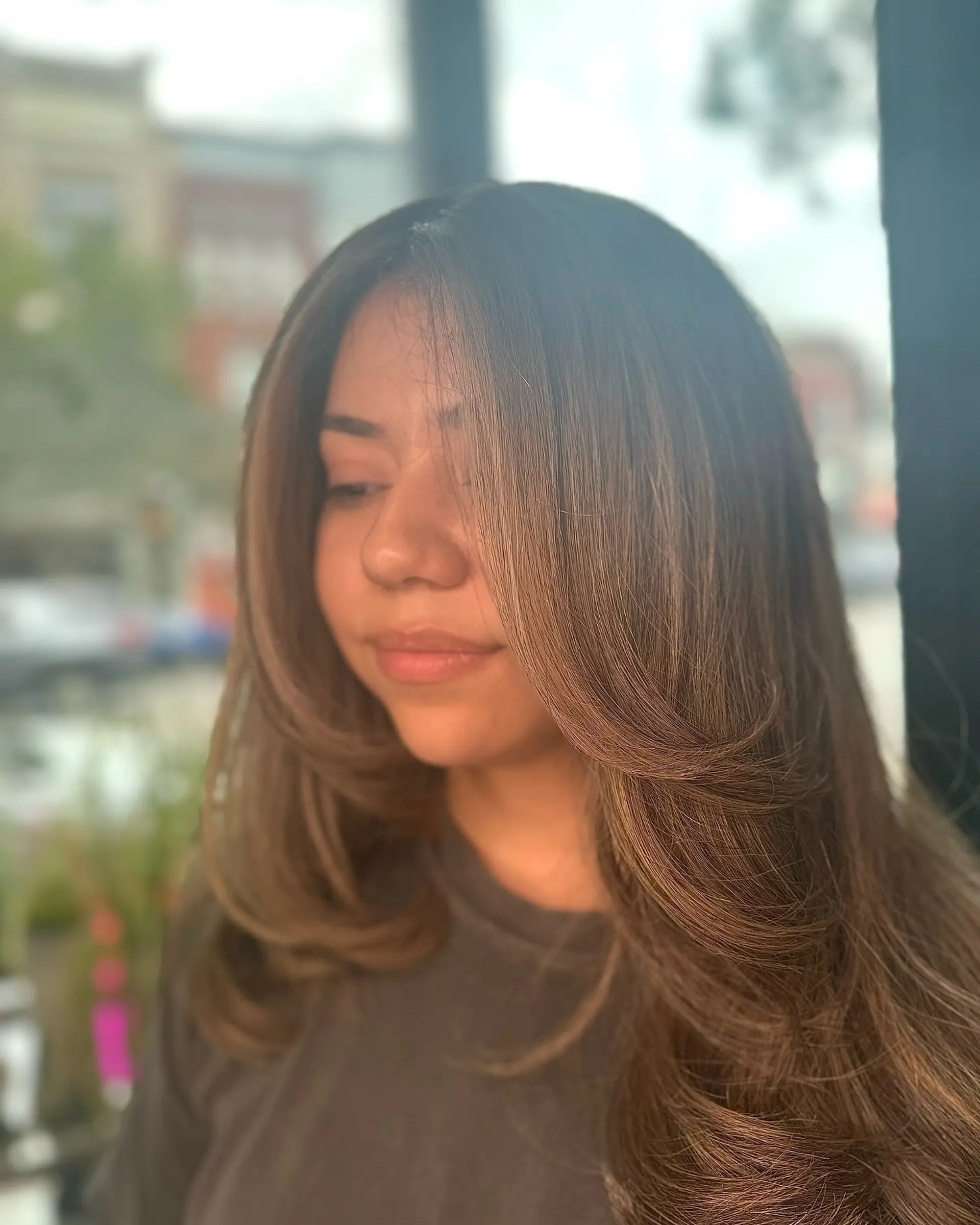 Long brown hair styled with bouncy, rounded face-framing layers and curved ends. 1