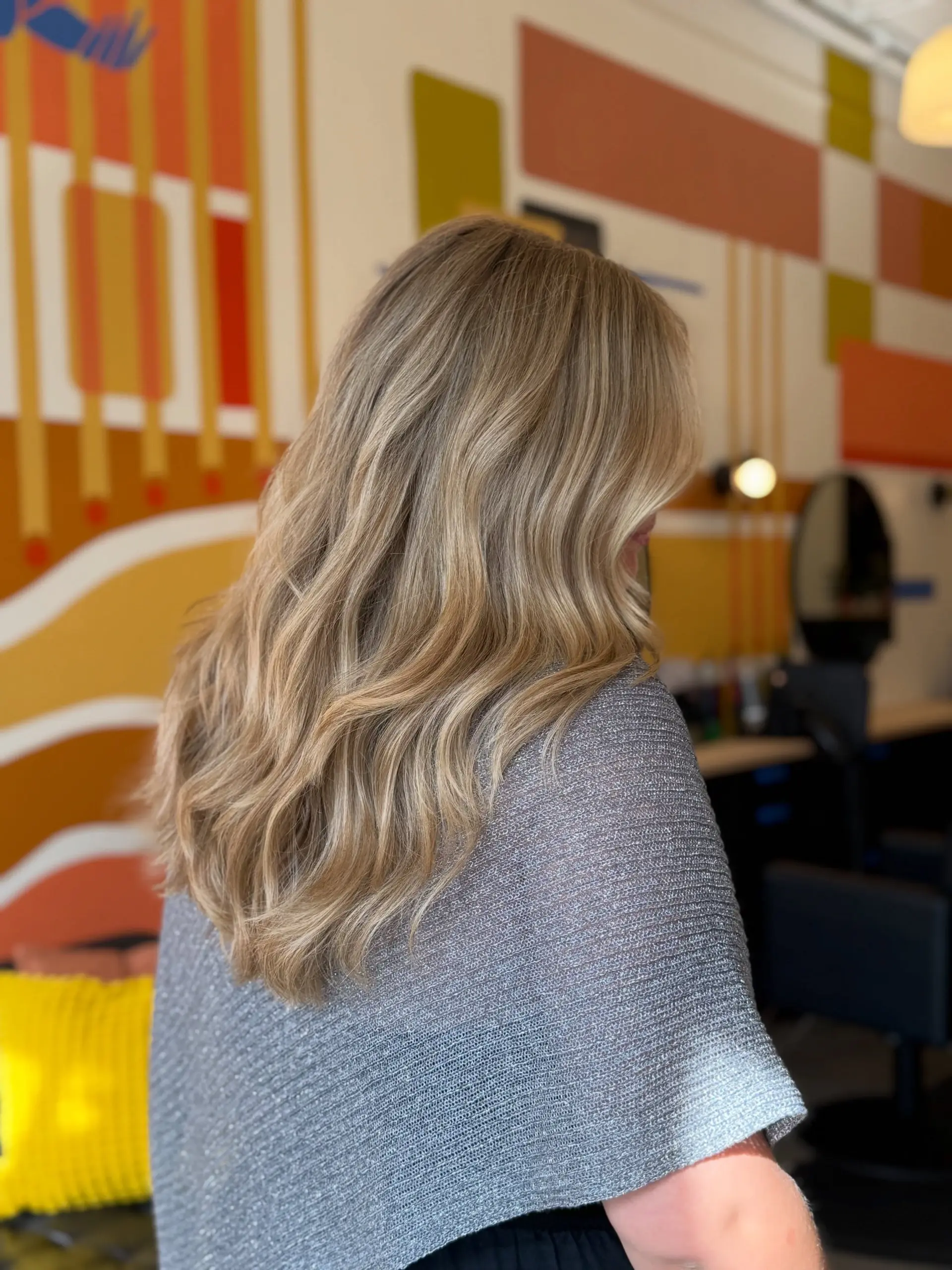 Long dimensional blonde balayage styled with effortless, soft loose waves. 1