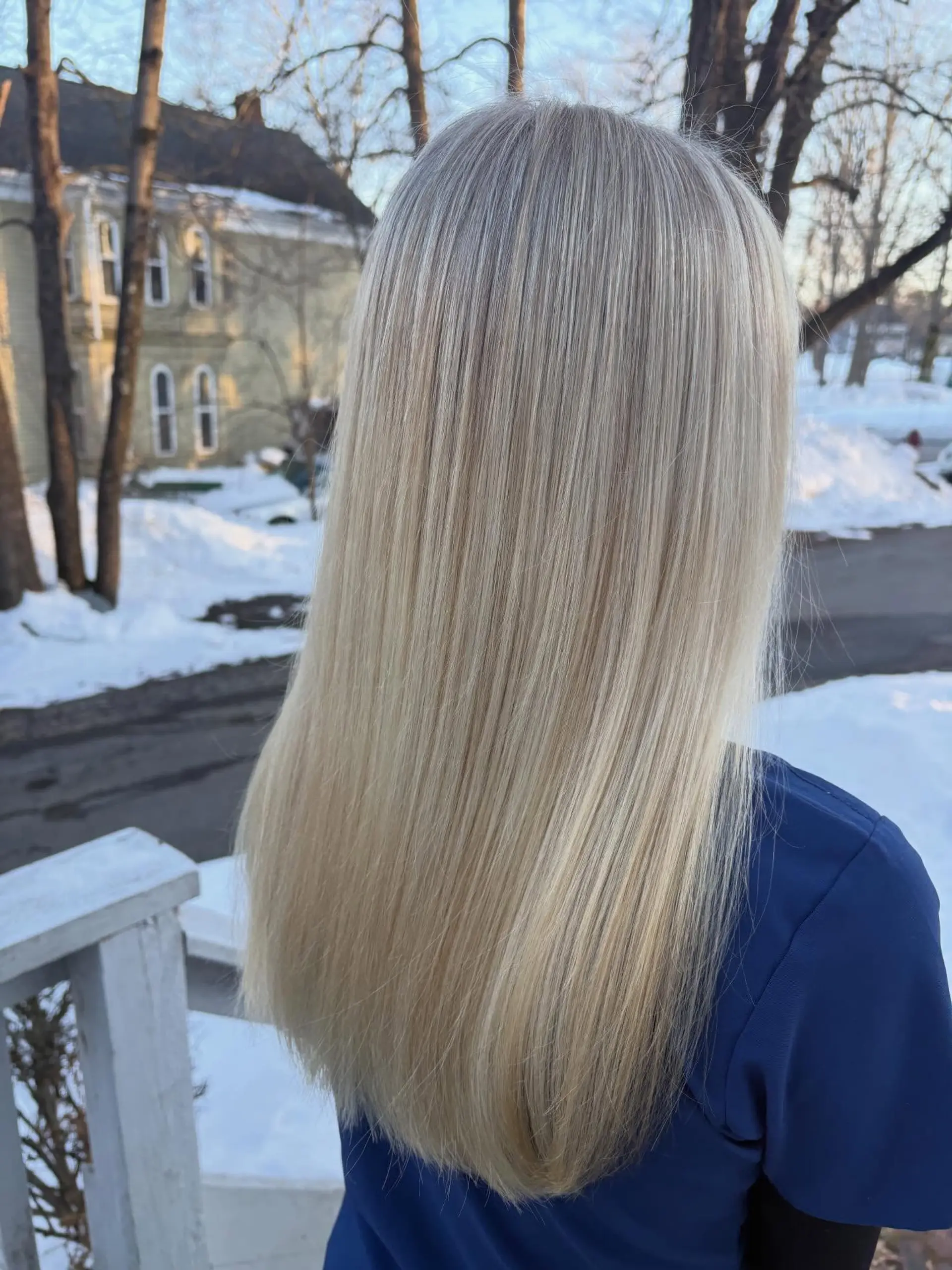 Long, silky straight blonde hair featuring finely blended highlights with a smooth blowout finish. 1