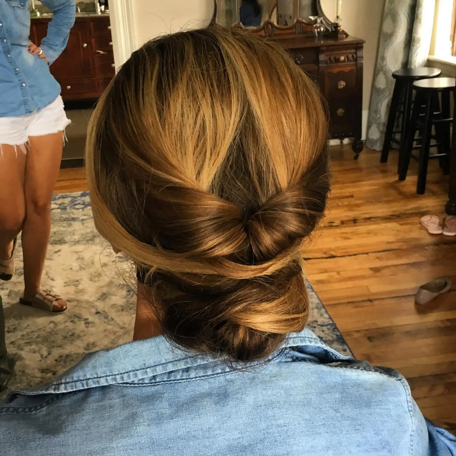 A romantic low chignon featuring gathered and twisted side sections wrapped neatly at the nape. 1