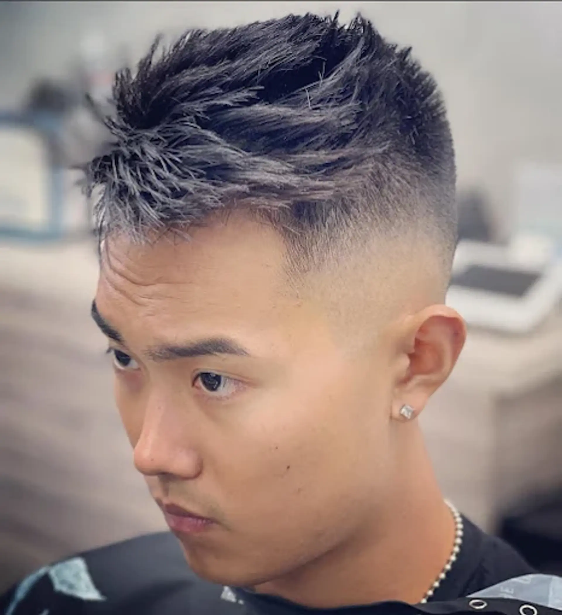 This haircut features a short, textured top with spiky definition, paired with a clean, high skin fade on the sides and back for a bold, contemporary look. 1