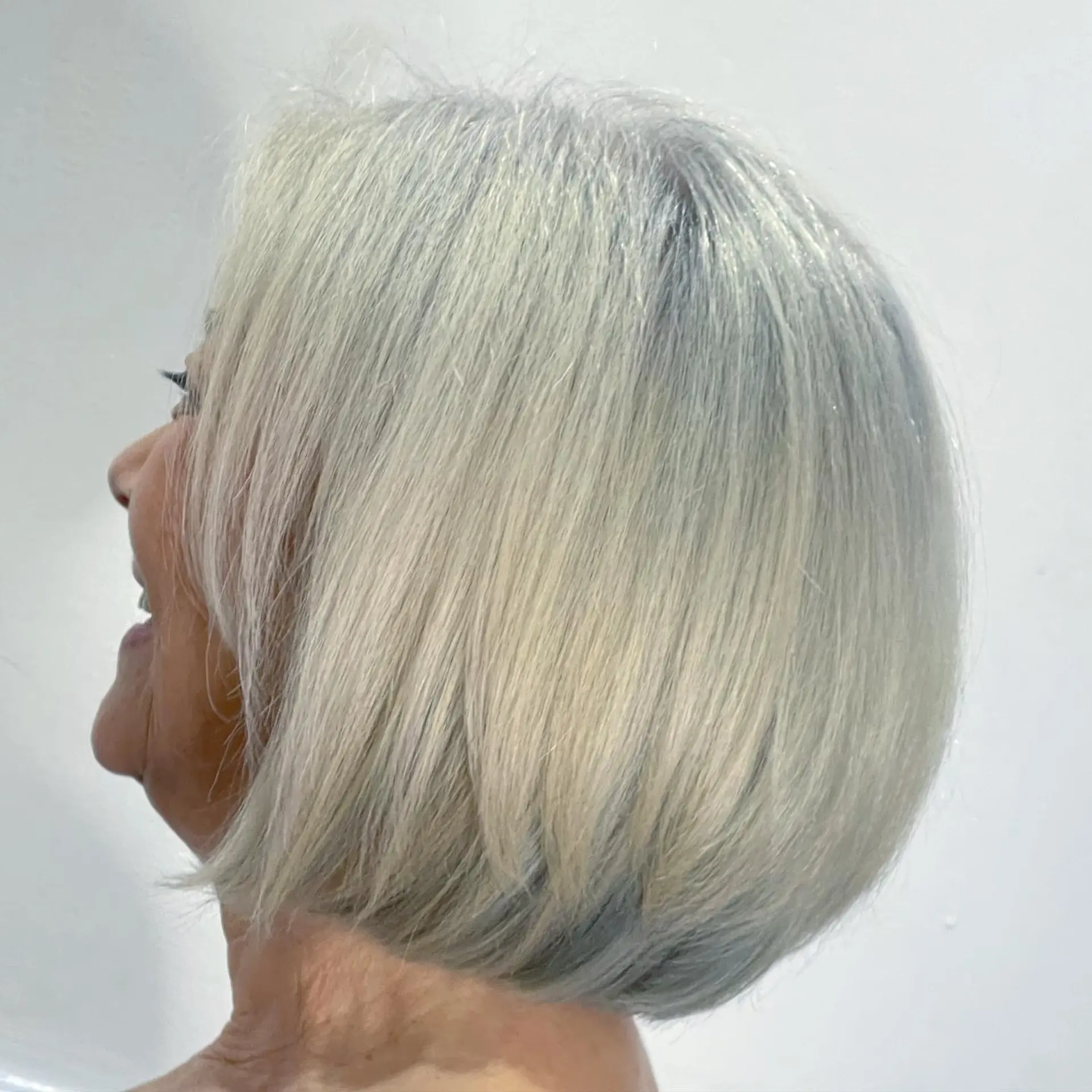 A sleek, chin-length rounded bob haircut featuring blended silver, white, and grey tones. 1