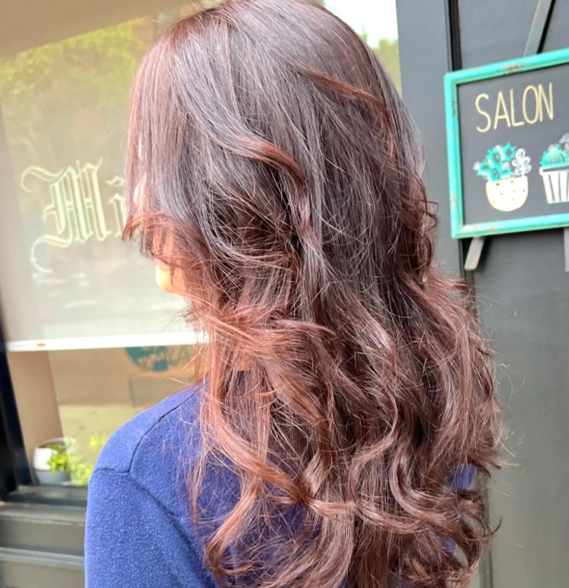 Long, wavy hair with a layered cut and a chocolate brown base with subtle copper balayage. 1