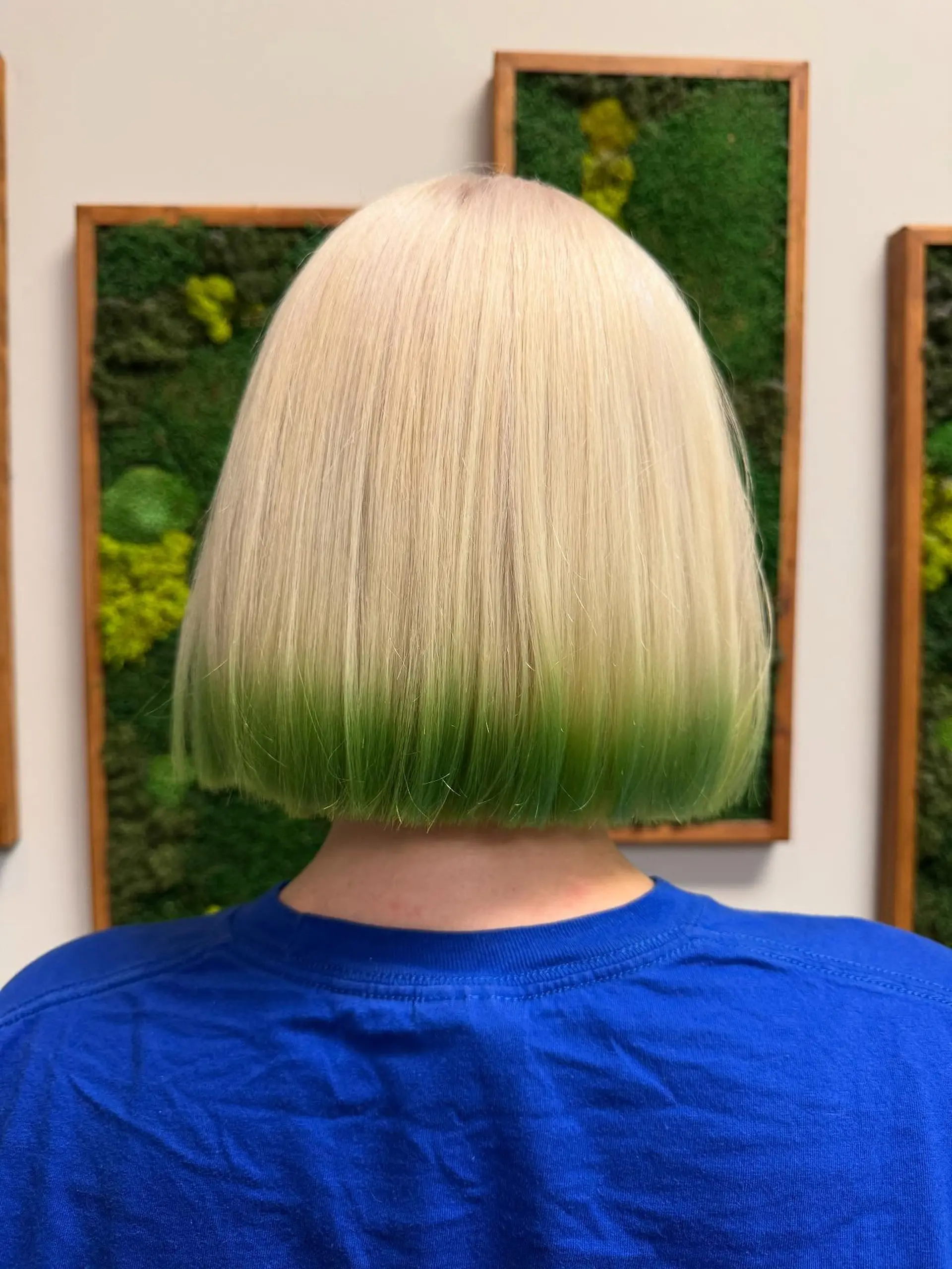A sleek, blunt-cut platinum blonde bob with vibrant green dip-dyed ends. 1