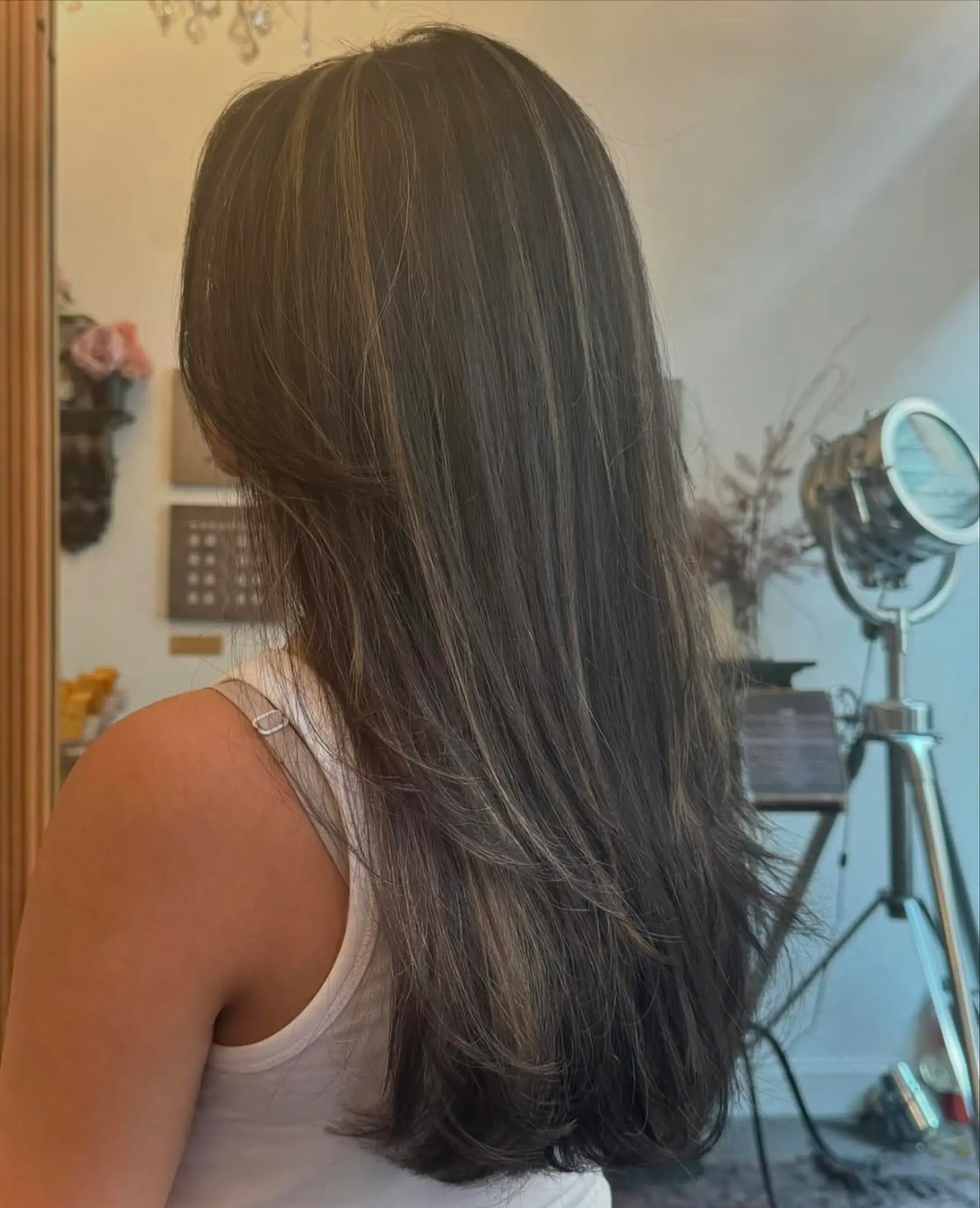 Long, straight, dark brown hair with ash blonde highlights, layered for volume with a sleek finish. 2