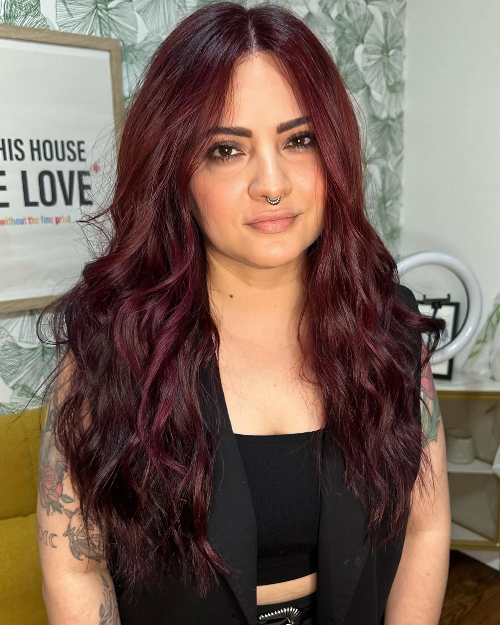 Long, layered hair colored in a rich deep wine burgundy tone, styled in loose, textured waves with a center part. 1