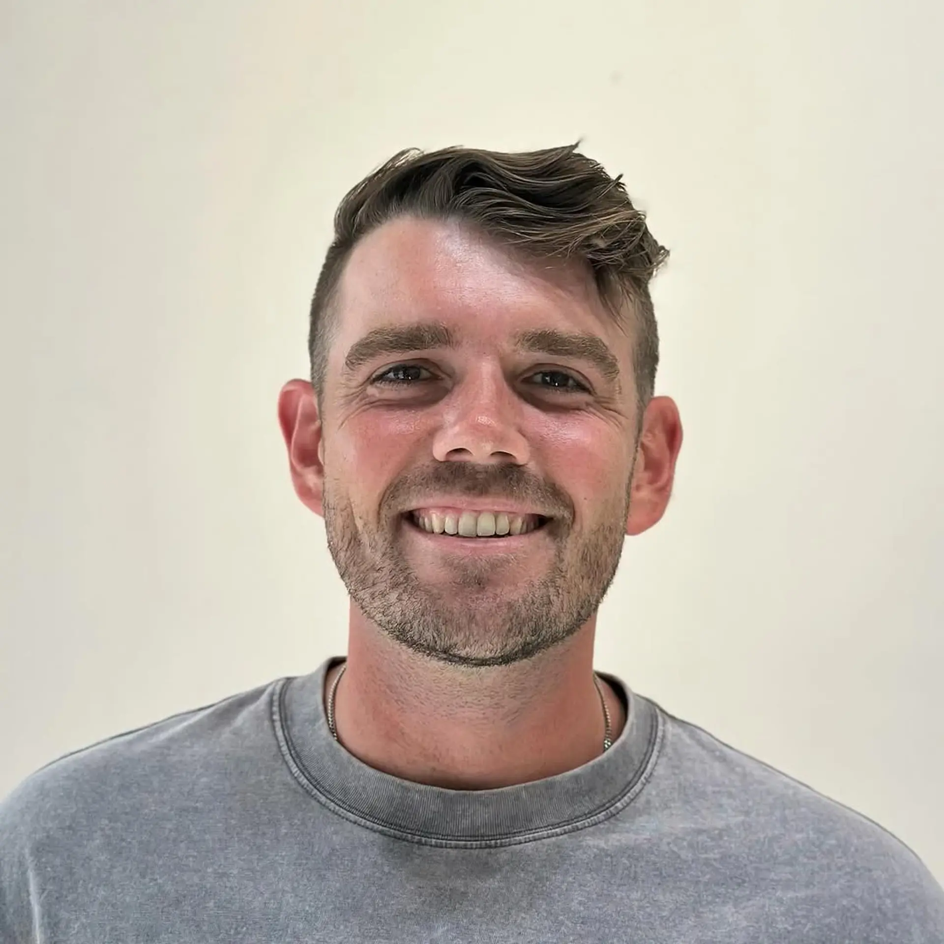 A short wavy hairstyle with an asymmetrical wave on top, contrasting neat sides, and a subtle low fade. 1