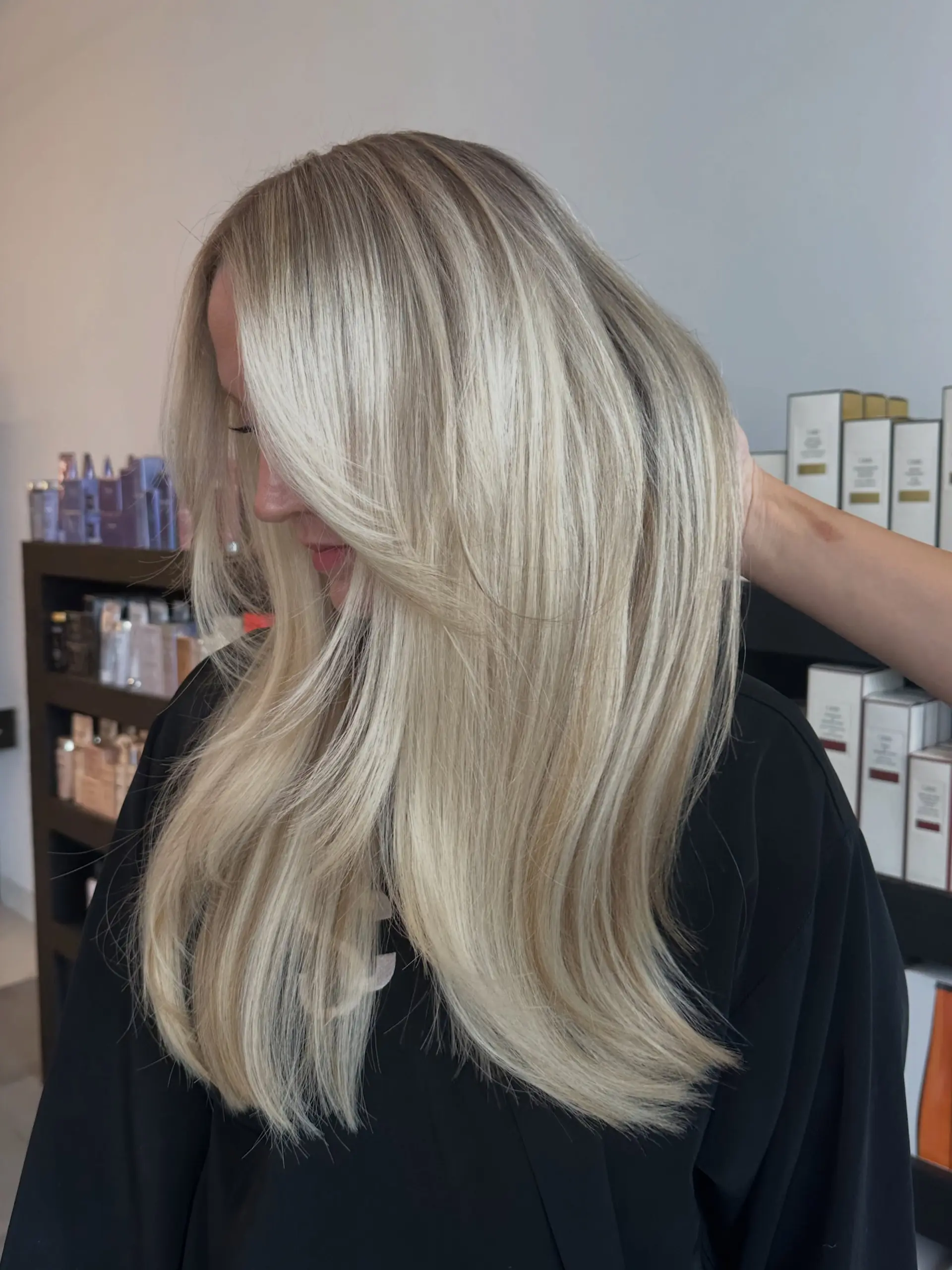 Long ash blonde hair with bright highlights, styled smooth and sleek with face-framing curtain layers. 1