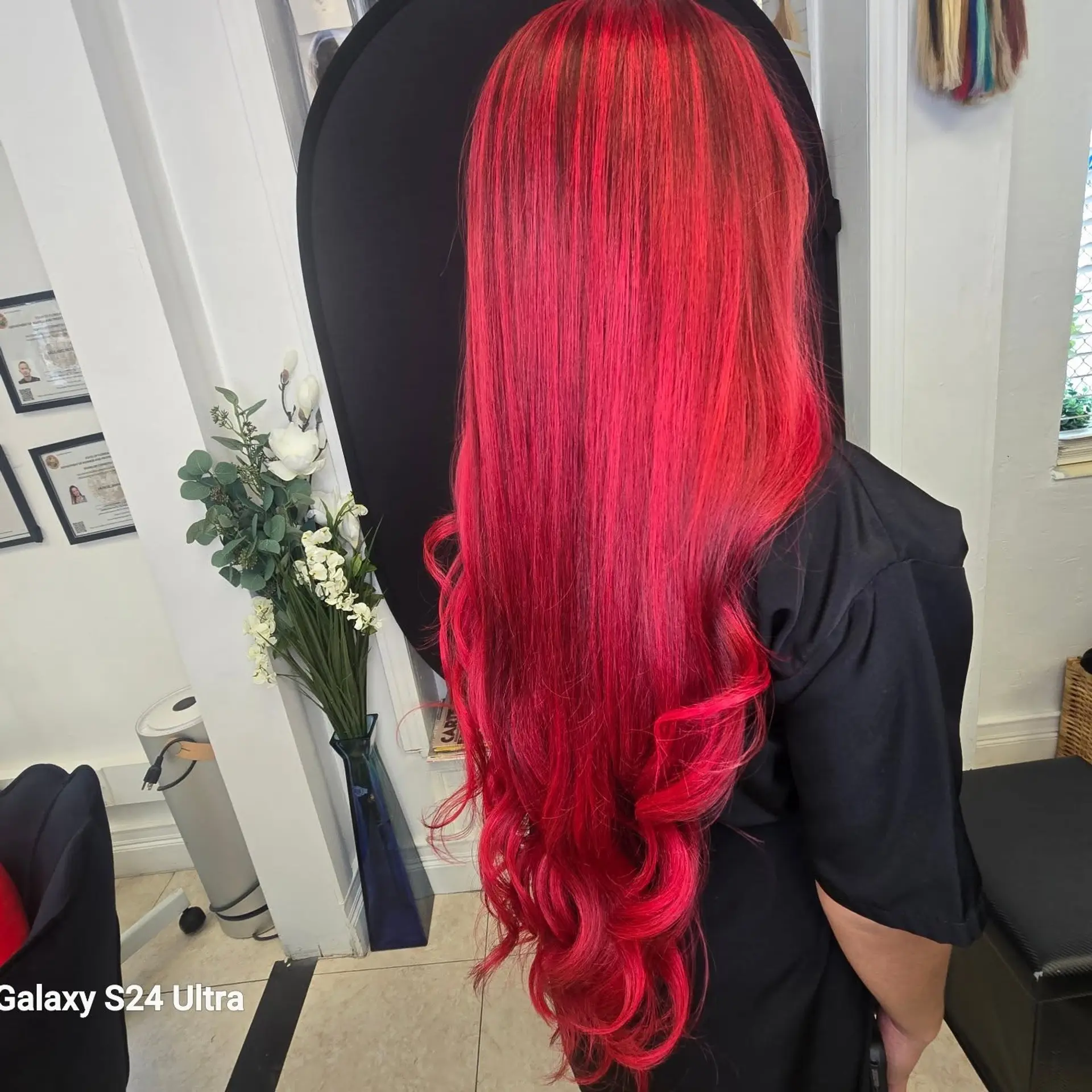 Vibrant bright red long hair styled straight at the top with loose curls at the ends. 1