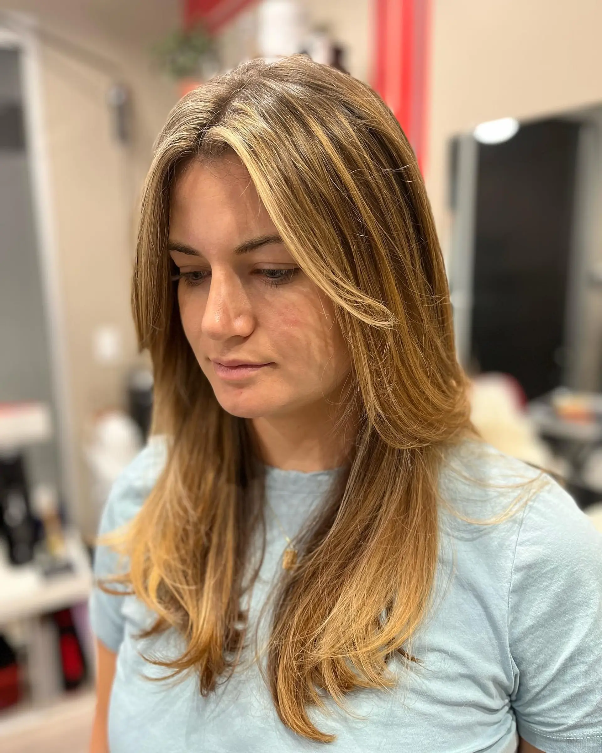 Long layered hairstyle with curtain bangs and face-framing layers. 1