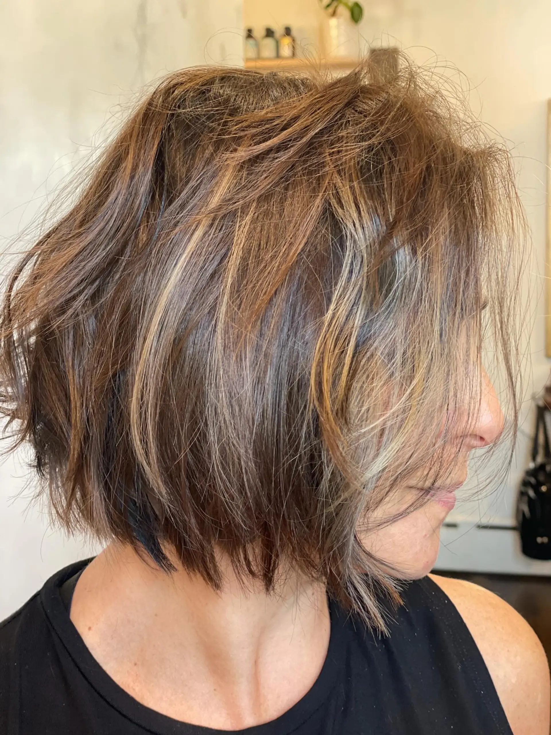 A chin-length textured bob featuring multi-tonal dimensional highlights in toffee, mocha, and vanilla hues. 1