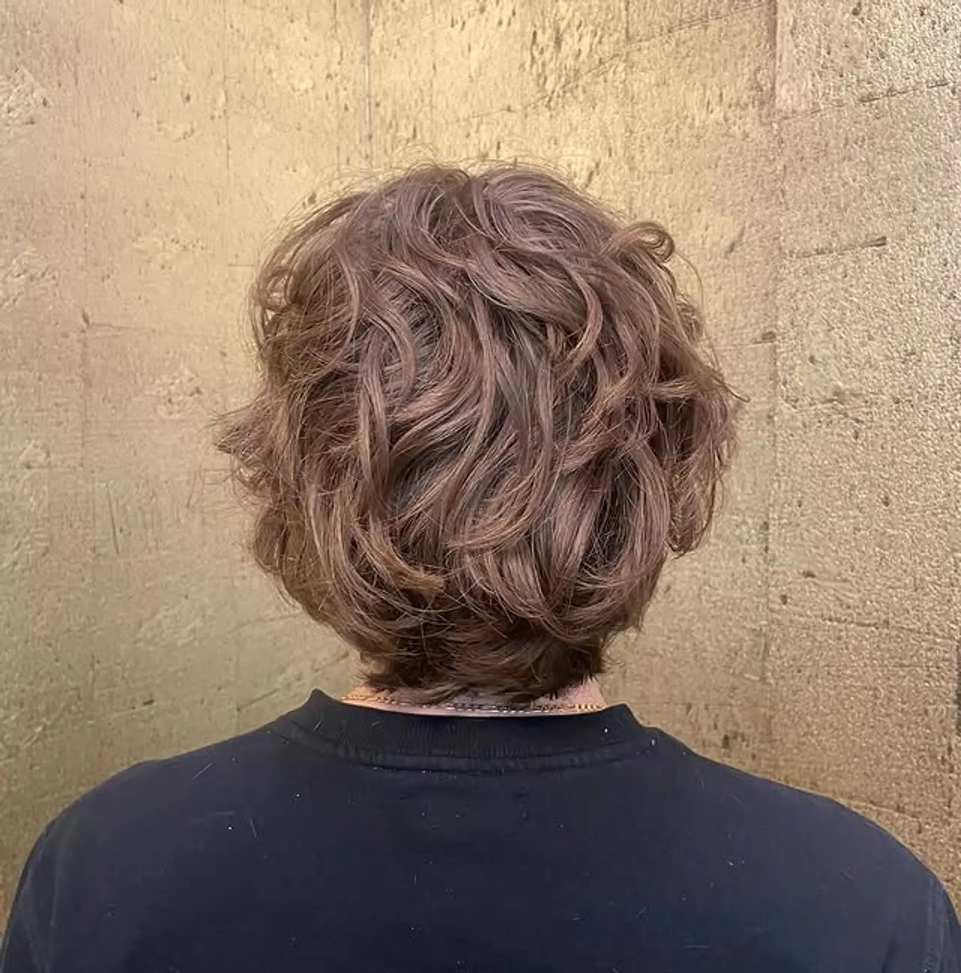 A short textured bob with natural, soft curls. 1