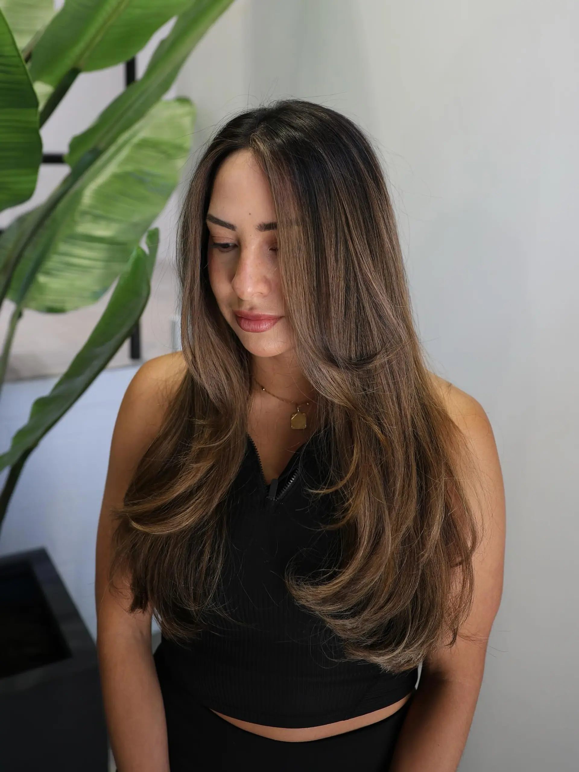 Long, layered hairstyle with subtle waves and face-framing layers. 1