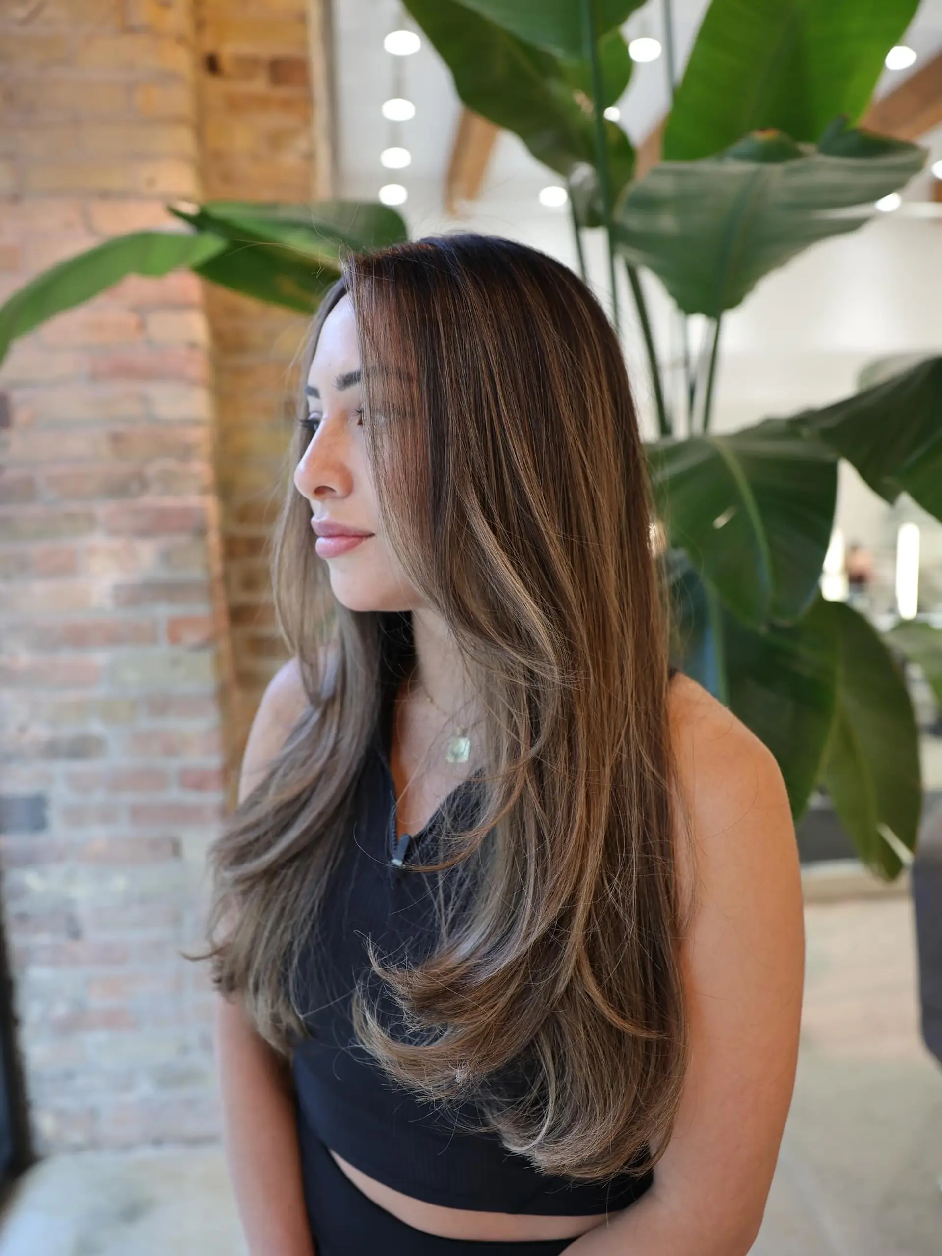 Long, layered hairstyle with subtle waves and face-framing layers. 3