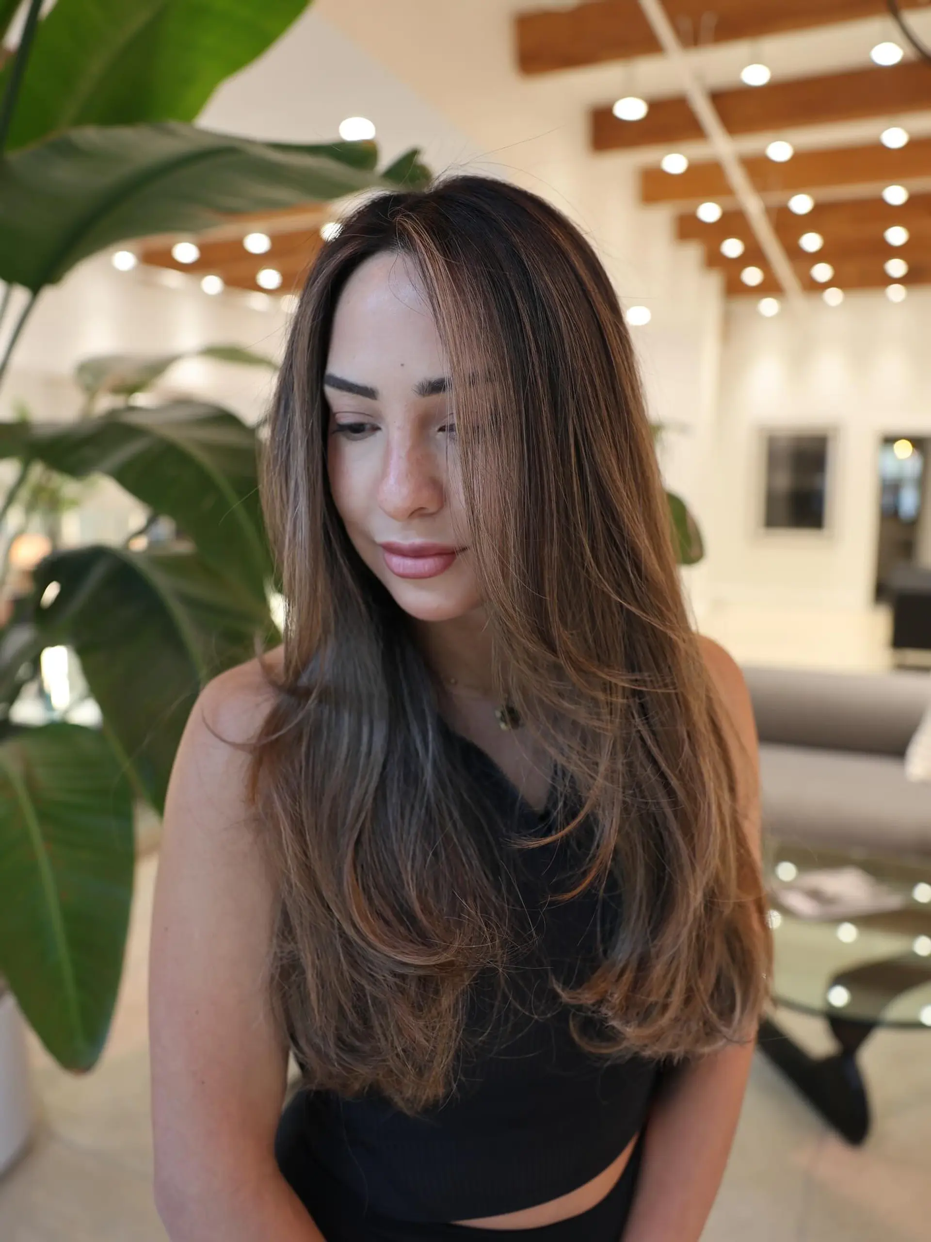 Long, layered hairstyle with subtle waves and face-framing layers. 4