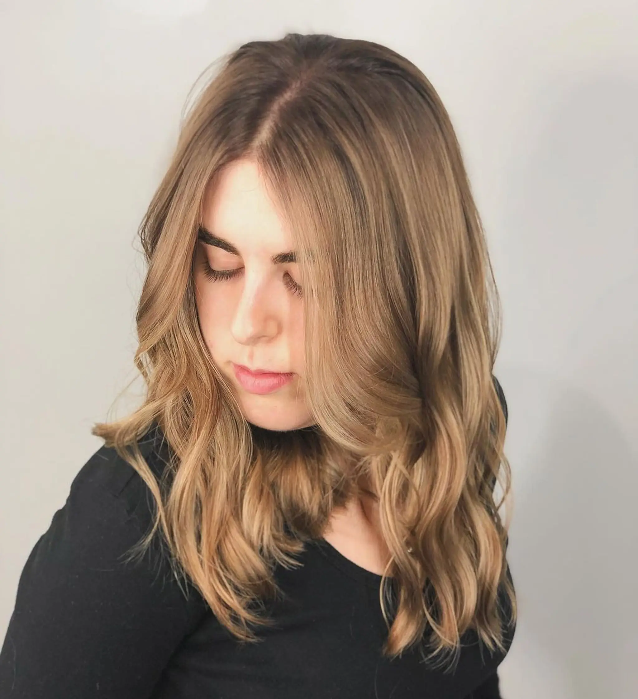 Soft waves with a middle part and layered cut, medium-length honey blonde hair with gentle face-framing highlights.
Stylist - @xcellent_jason