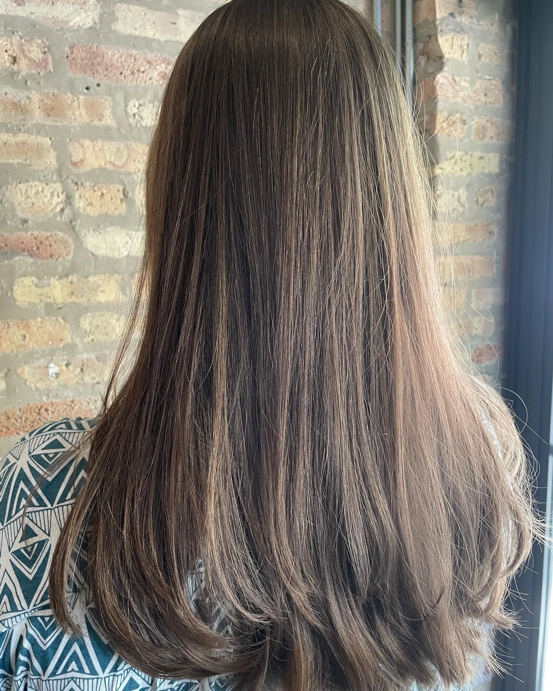 Long, healthy medium brown hair with soft lower layering and smooth, beveled ends. 1