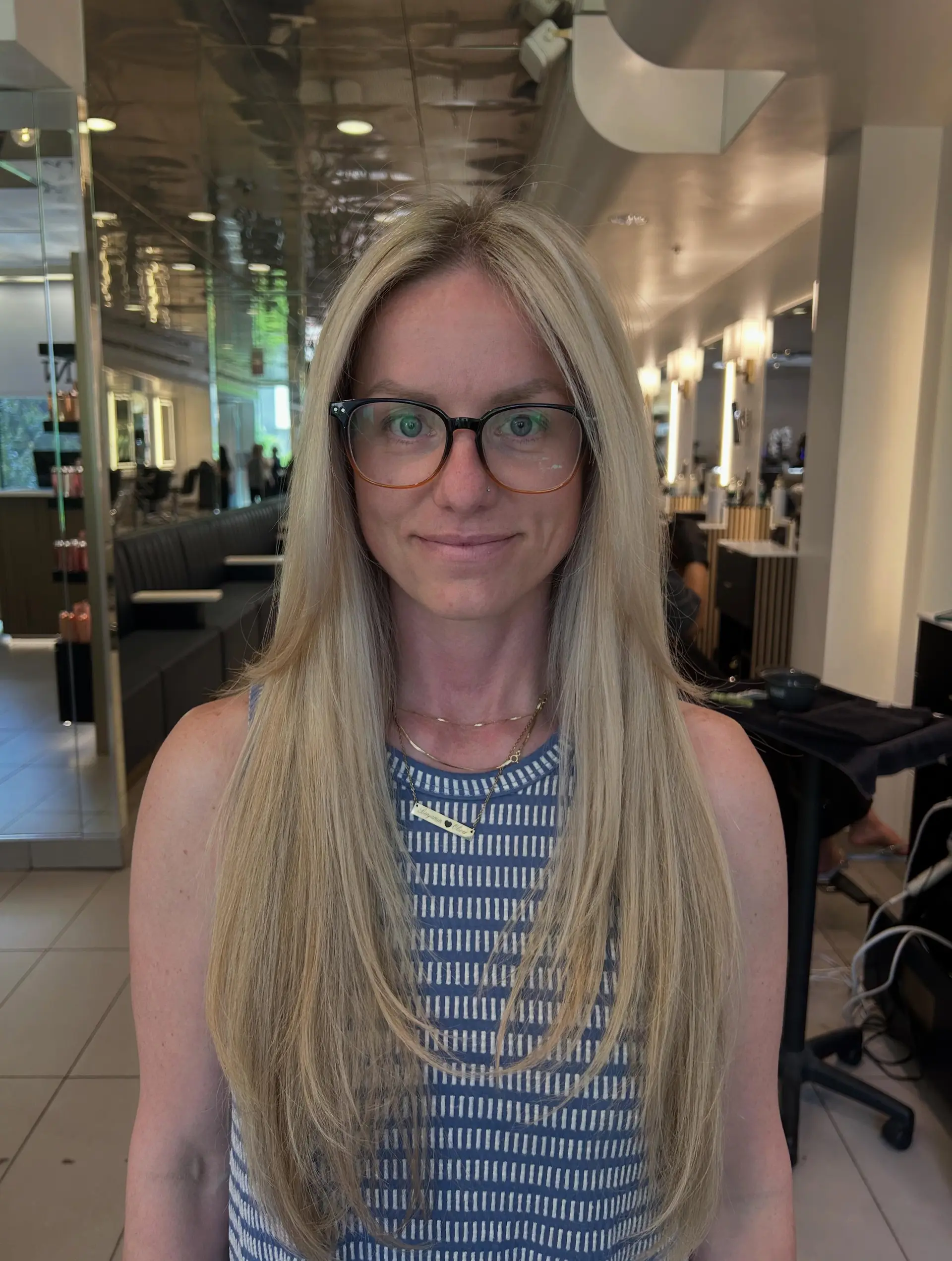 Long, sleek blonde hair parted in the middle with subtle face-framing layers. 1