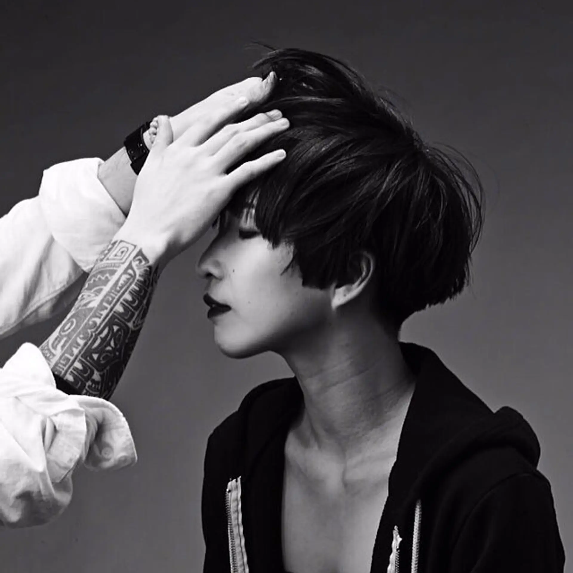 A modern, edgy short crop featuring textured volume through the crown and sharp, straight-across bangs framing the brow. 1