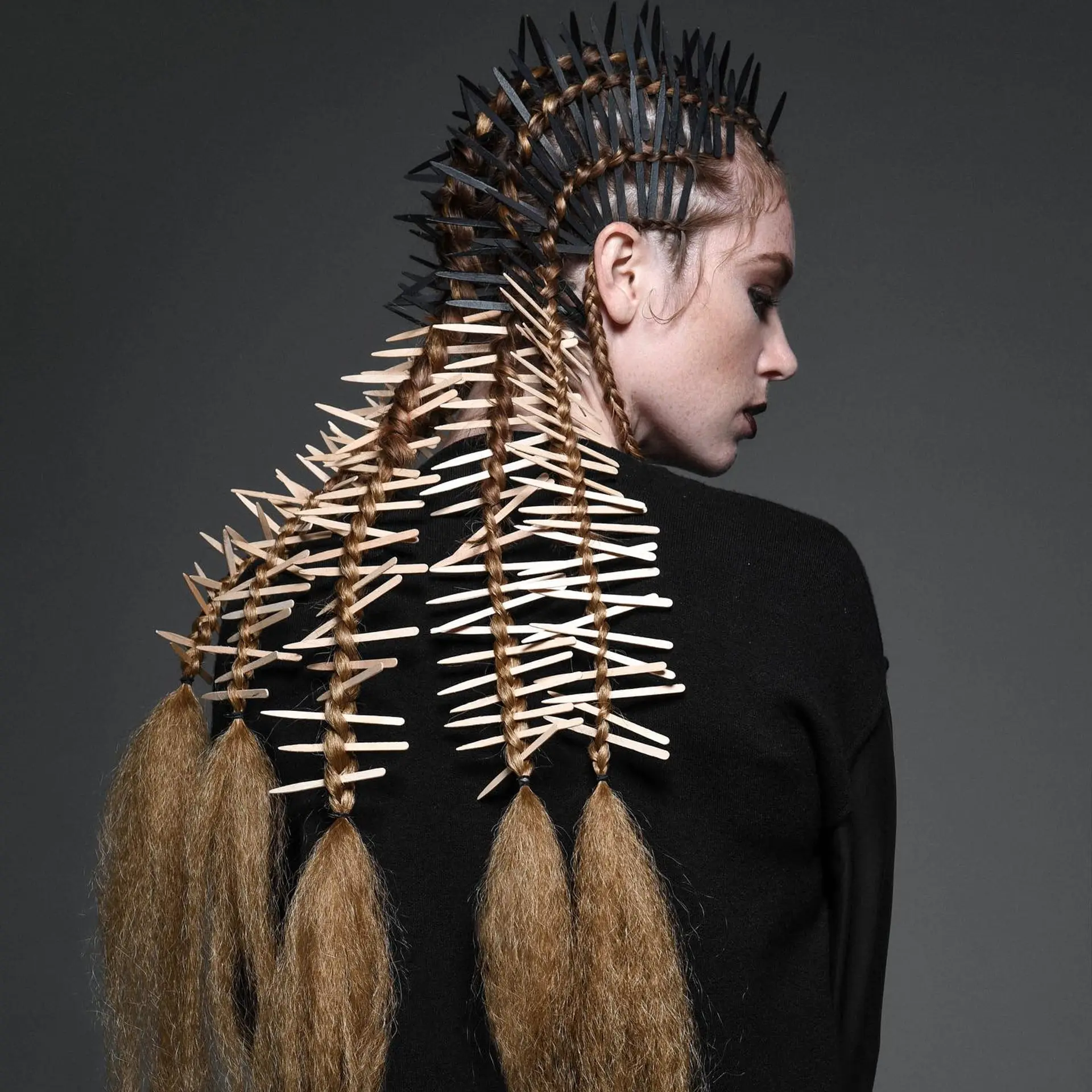 An avant-garde editorial braided style accented with quill-like elements and finished with textured crimped tails. 1