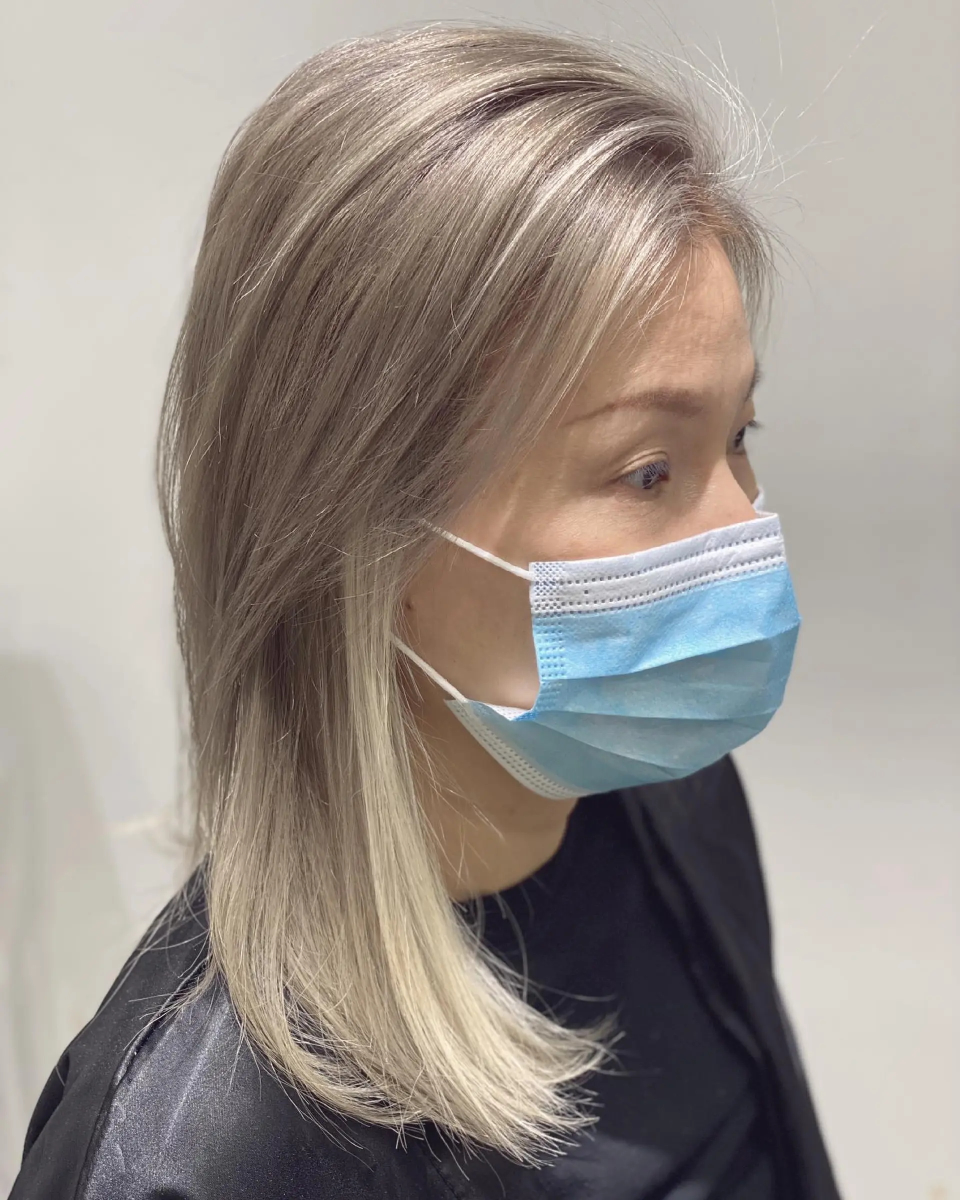 A stylish medium length haircut with ash blonde color and subtle layers. 1