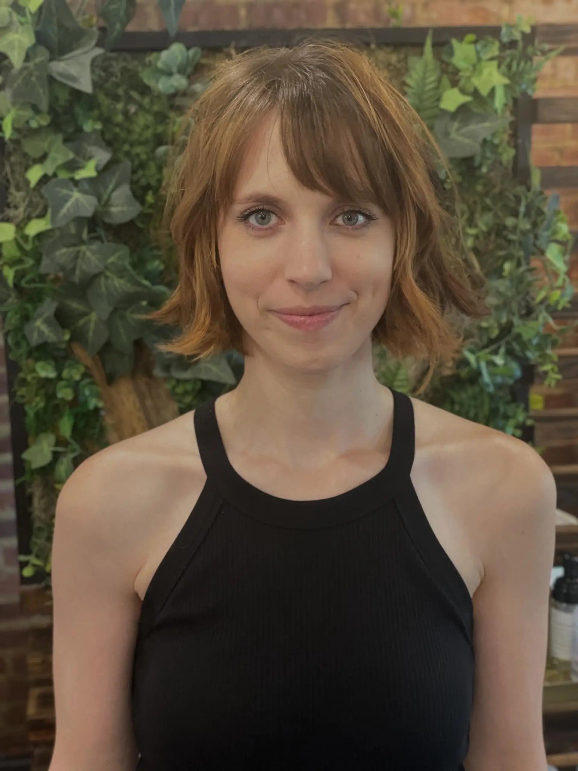 A textured chin-length wavy bob with a wispy full fringe and dimensional golden copper color. Current Cut My Hair service: $215 for haircut and included finish only; displayed color is not included. 1