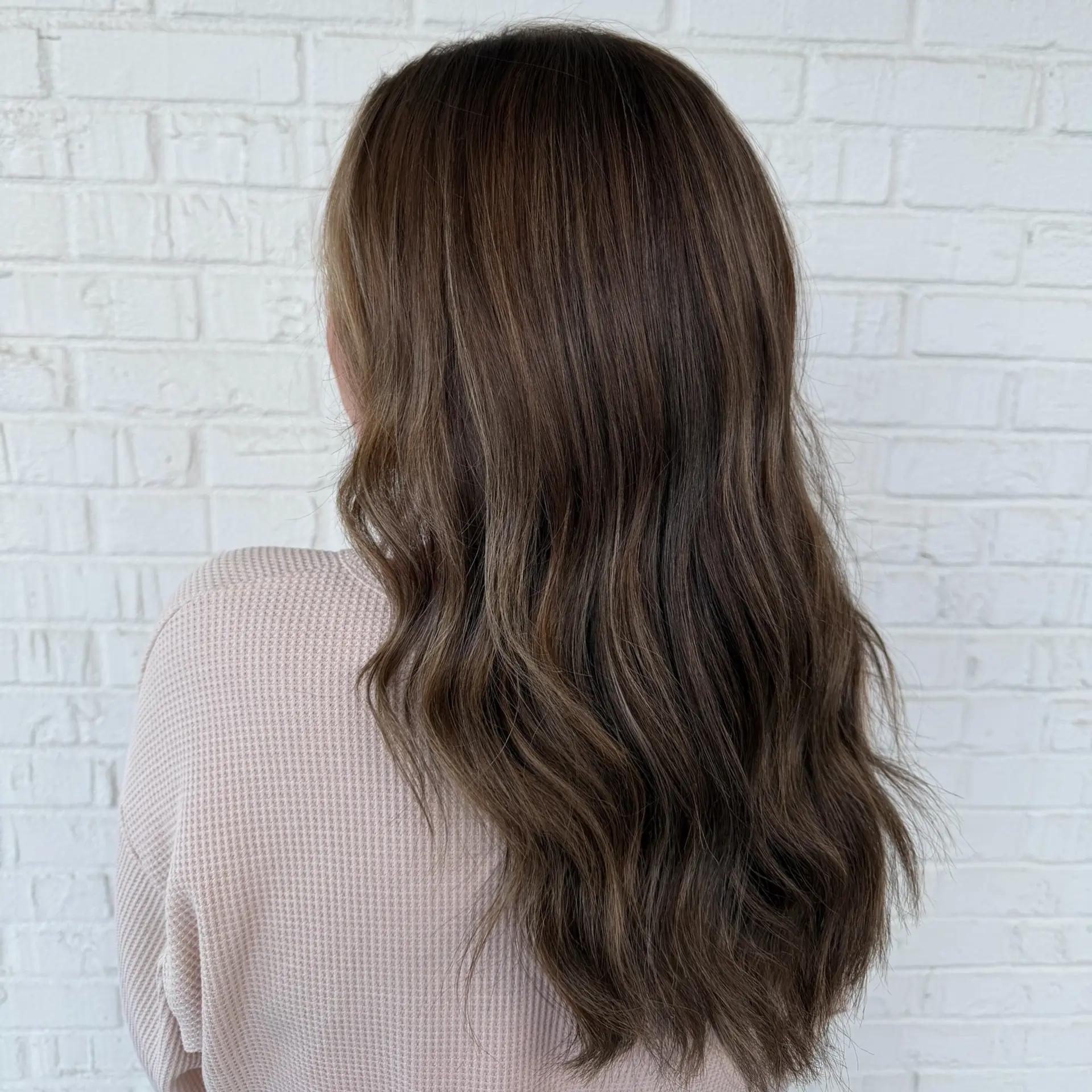 Long chocolate brunette hair styled with soft, cascading loose waves and a healthy shine. 1
