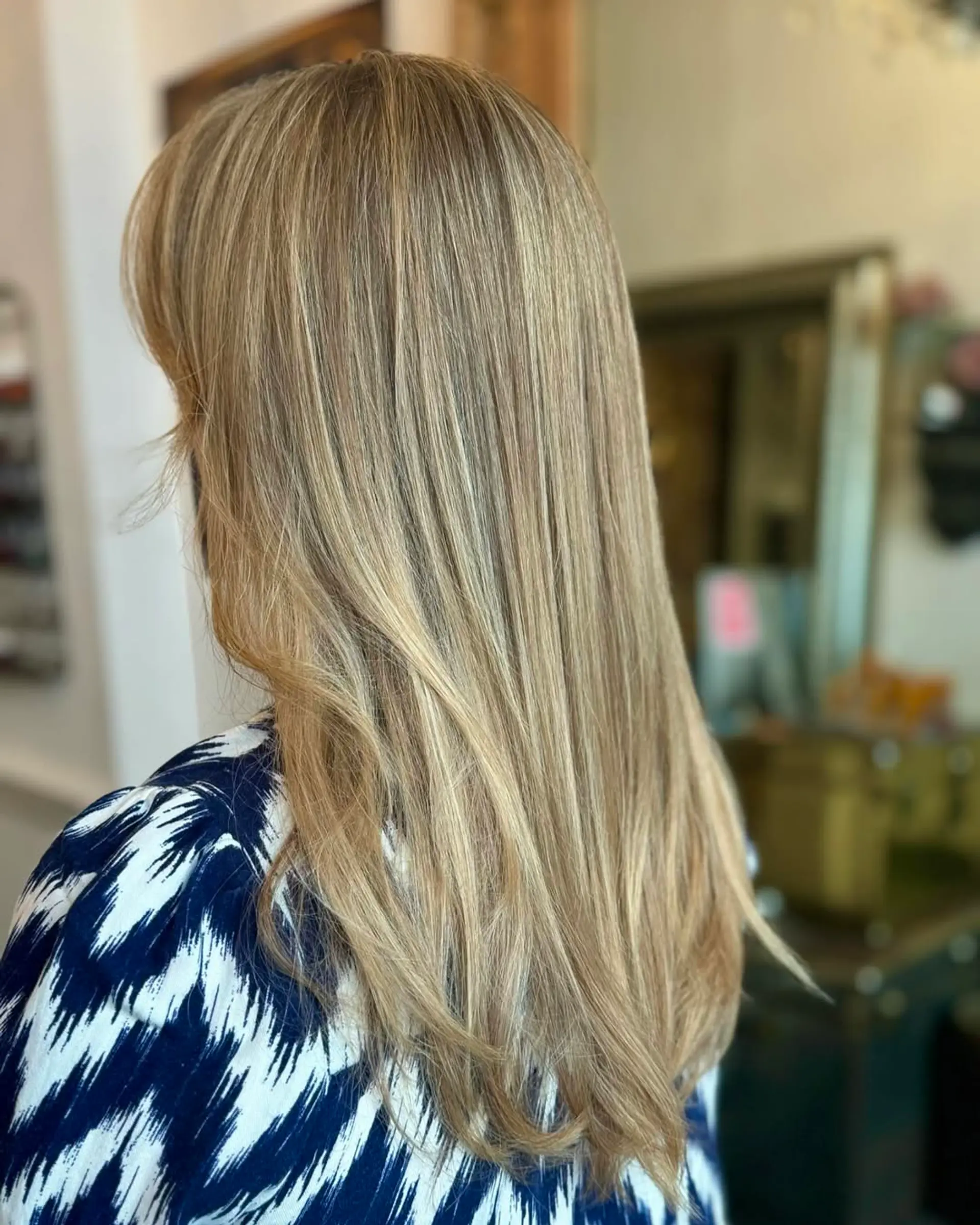 Long, straight, layered hair in golden blonde with highlights and a natural shine. 1