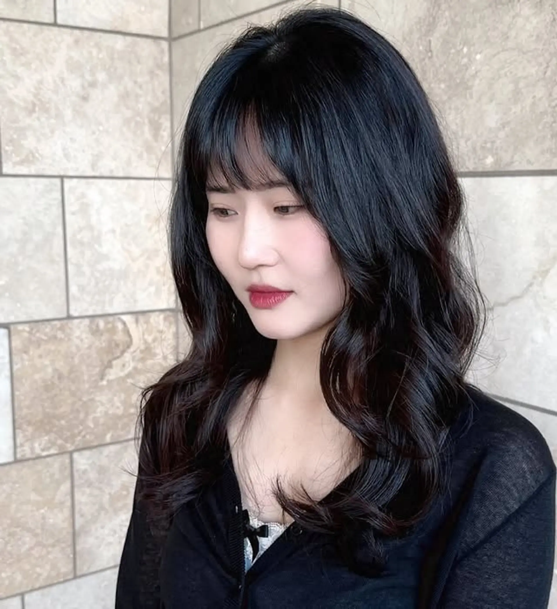 Soft waves with face-framing curtain bangs, providing a modern and romantic look. 1