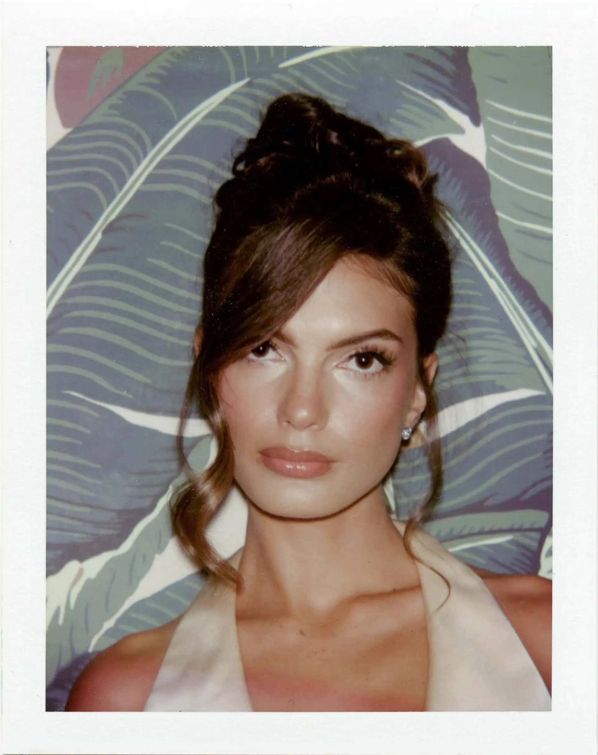 An elegant high updo with a side-swept fringe and soft face-framing curls. 1