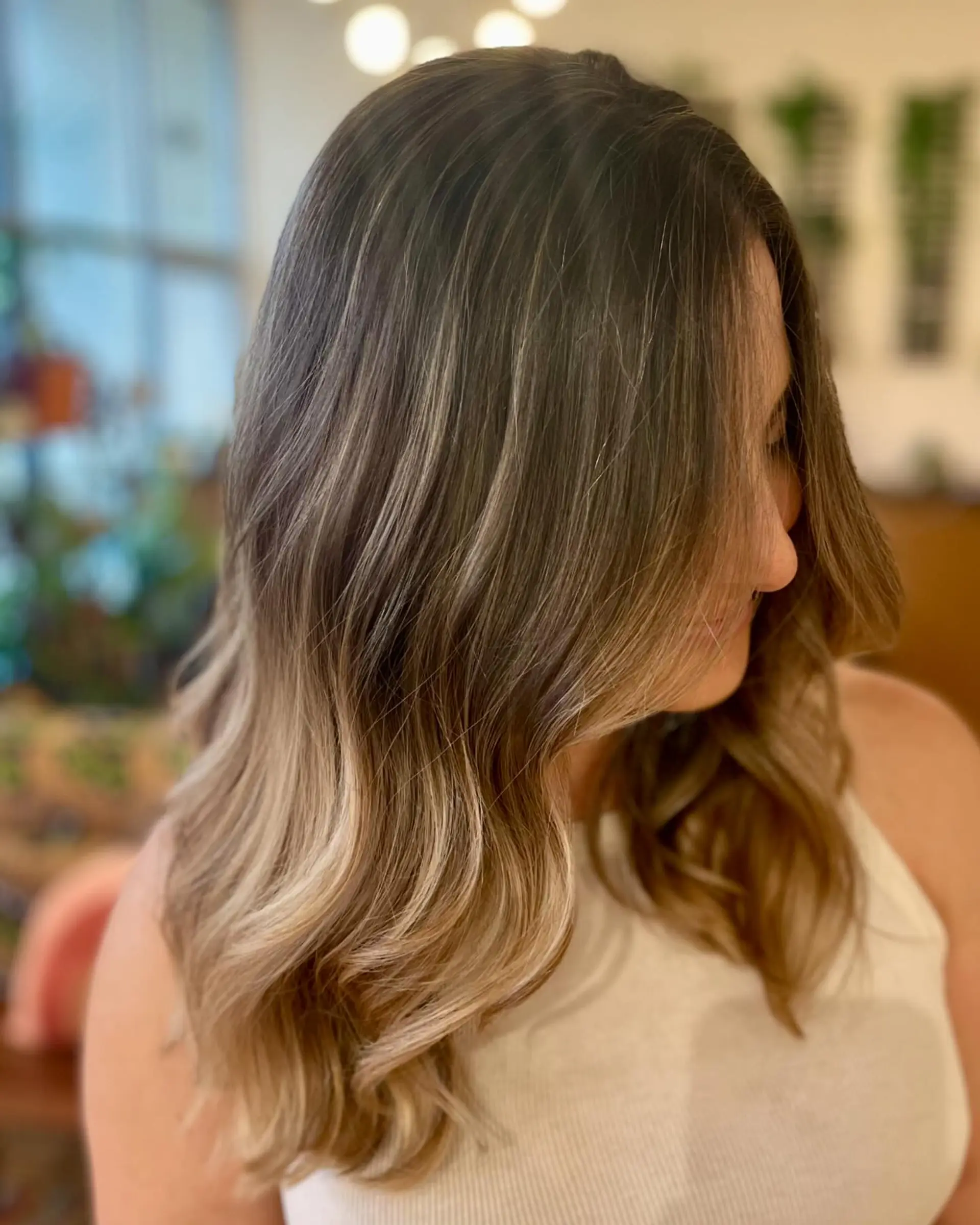 Long brown hair enriched with natural-looking blonde babylights and styled into soft, flowing waves. 1