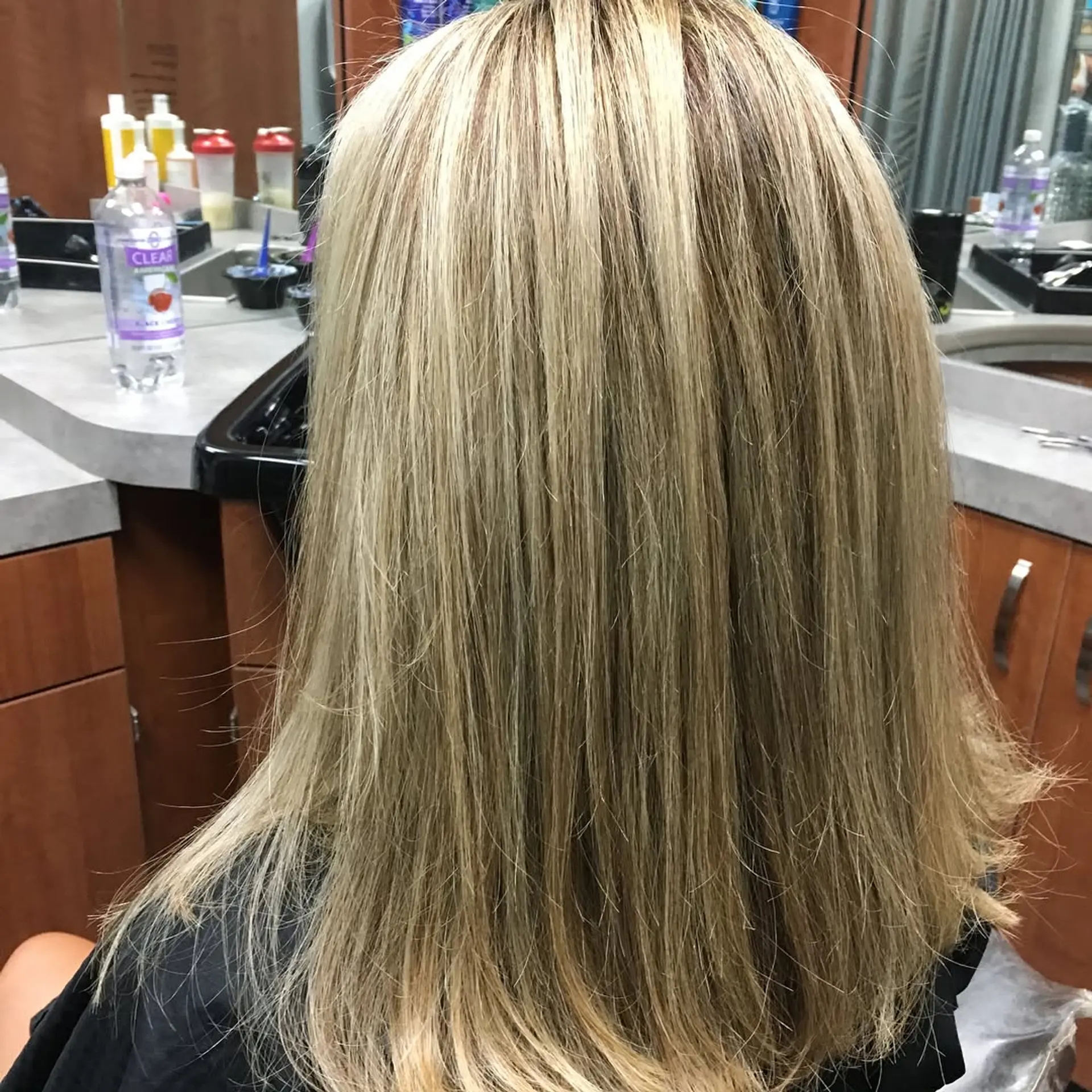 Smooth, straight medium-length blonde hair with subtle dimensional highlights and a neat finish. 1