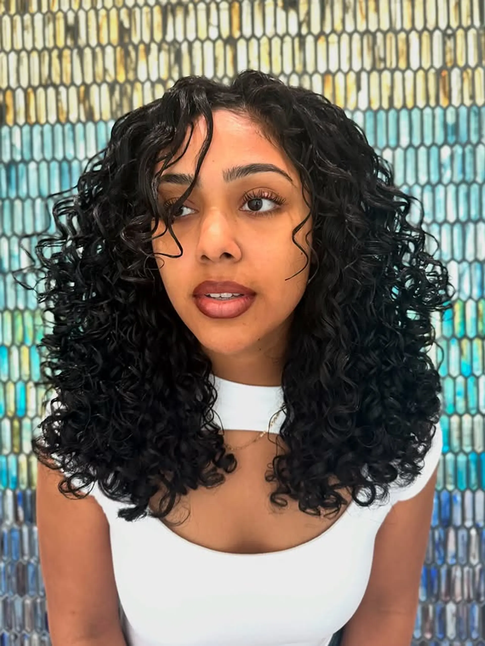 A trendy mid-length shag haircut designed for curly hair, featuring defined curls and layers. 1