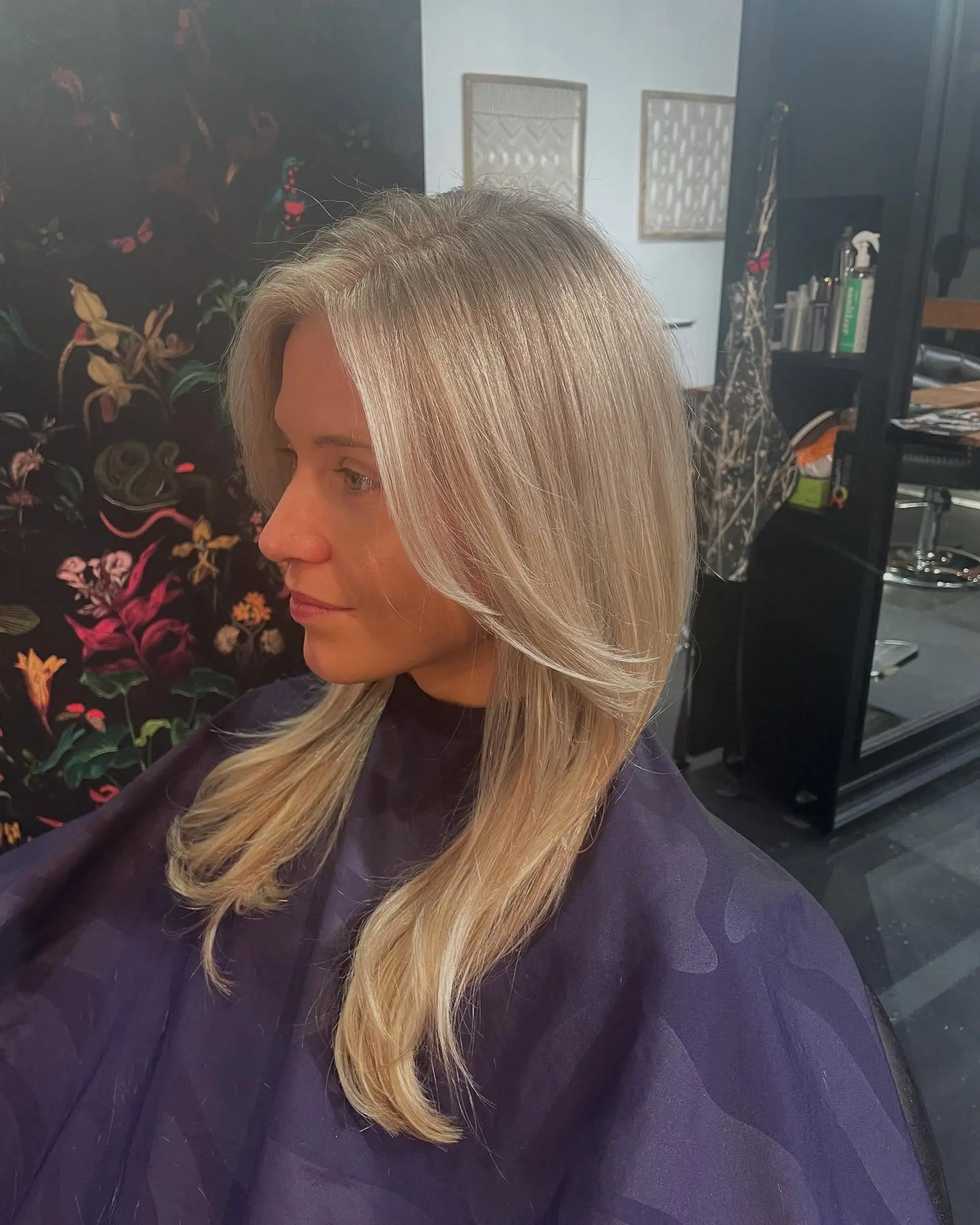 Long cool-toned blonde hair featuring blended full highlights and soft face-framing layers with a smooth blowout finish. 1