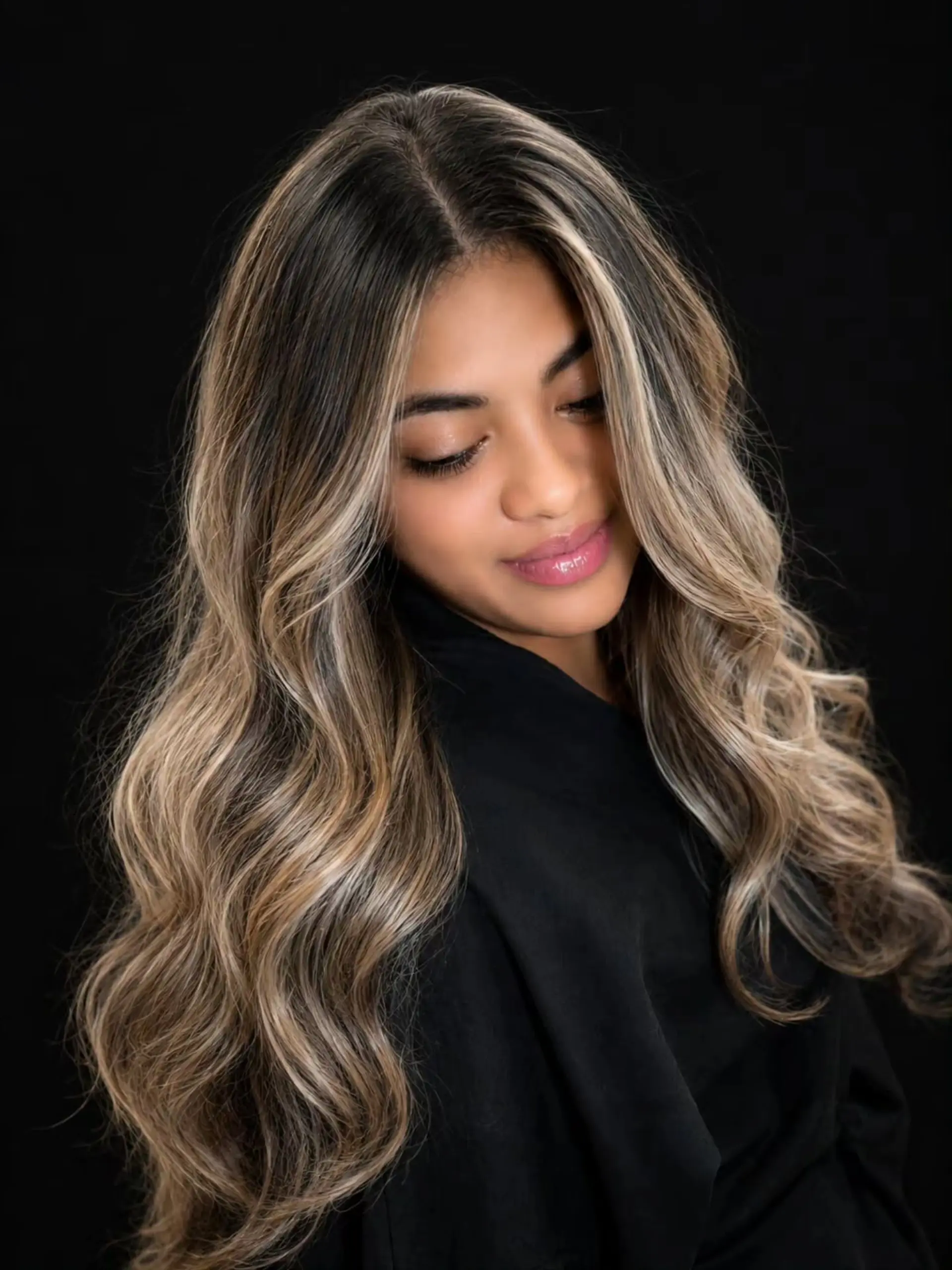 Long, voluminous dark brown hair with soft waves, featuring seamless ash blonde balayage highlights and bright face-framing money pieces. 1