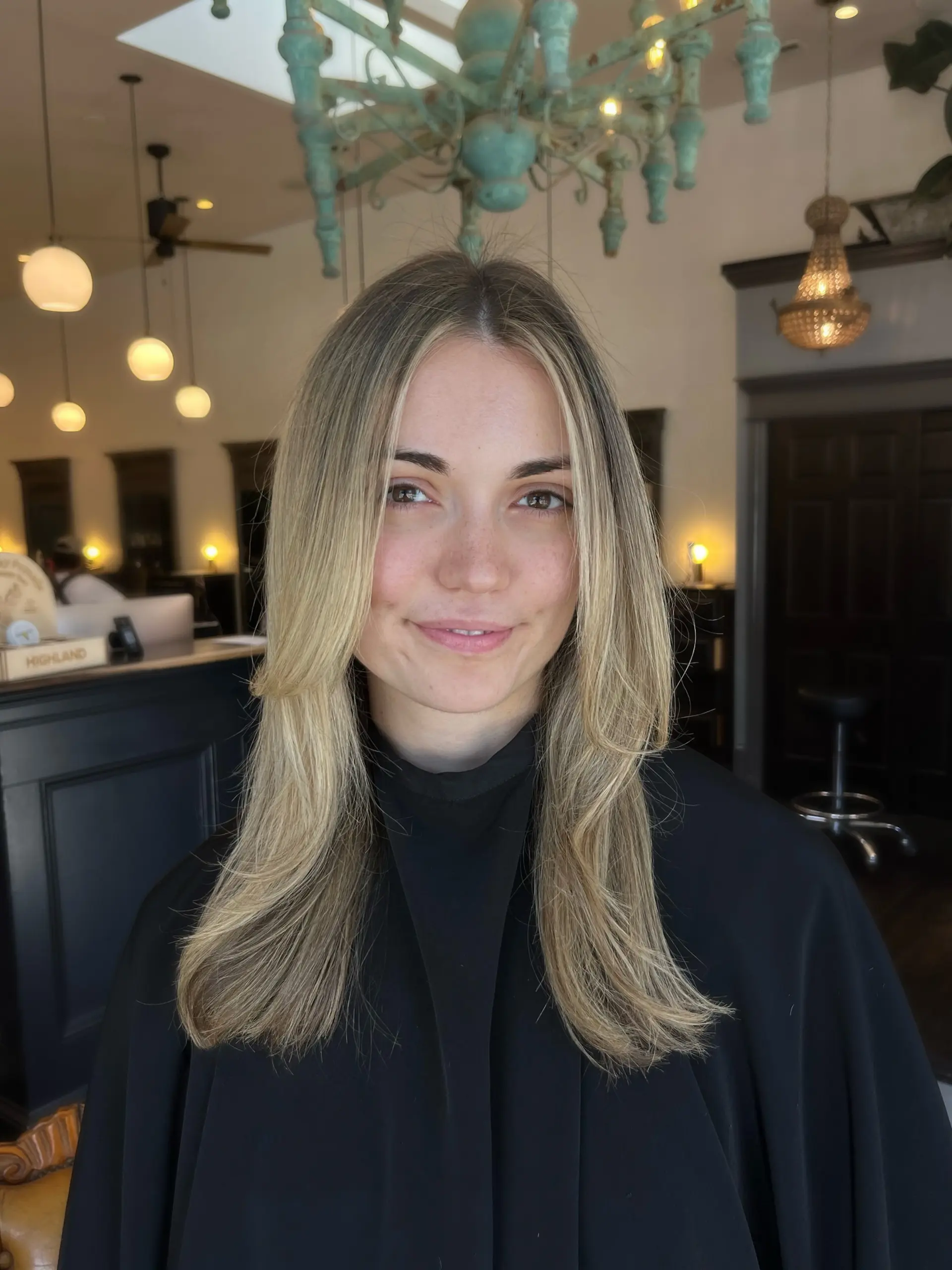 Long creamy blonde hair cut with face-framing layers and styled with a smooth, polished blowout. 1